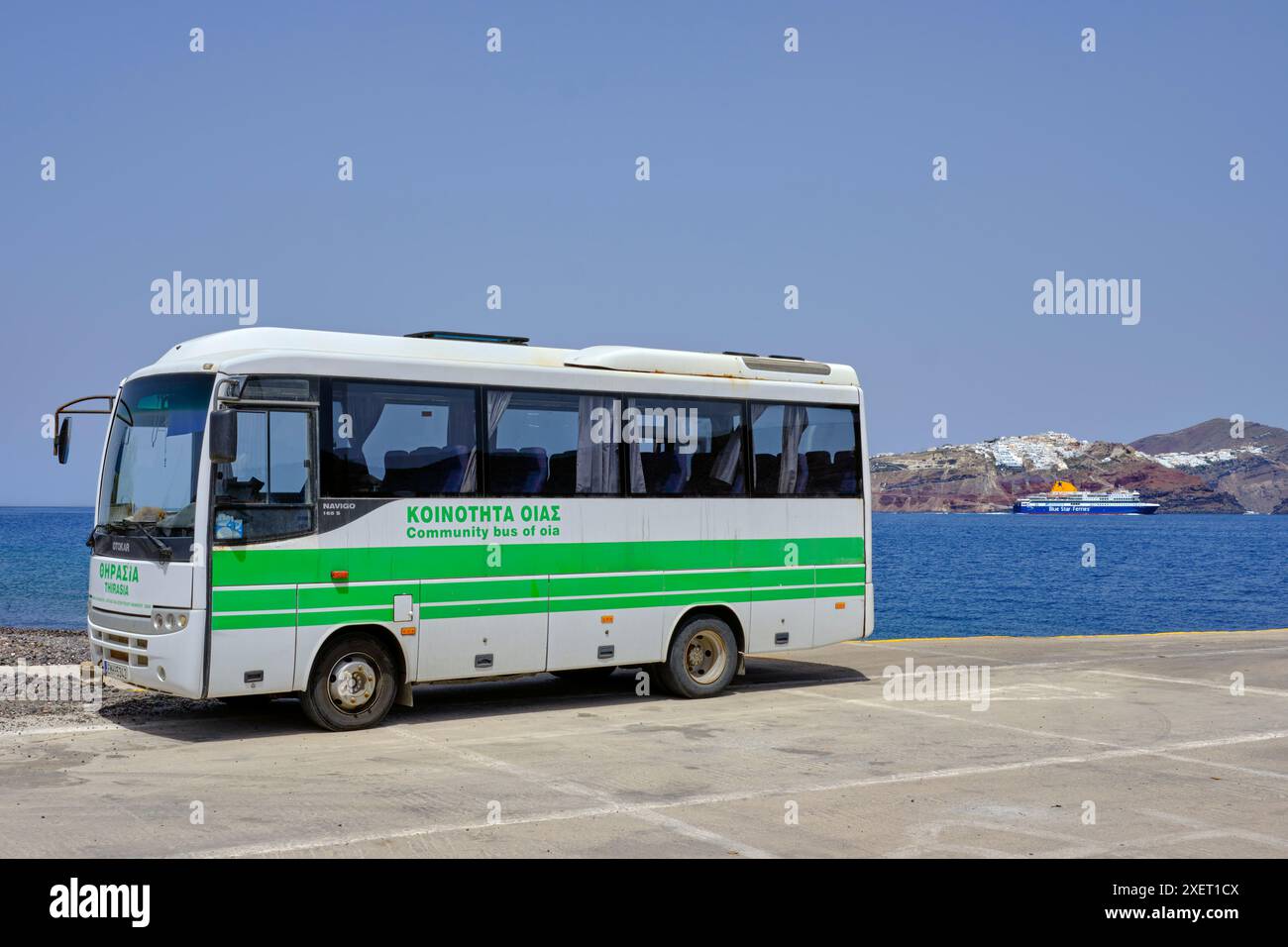 L'autobus dell'isola al porto di Riva, con Santorini in lontananza. Thirasia, Isole Cicladi, Grecia. Foto Stock