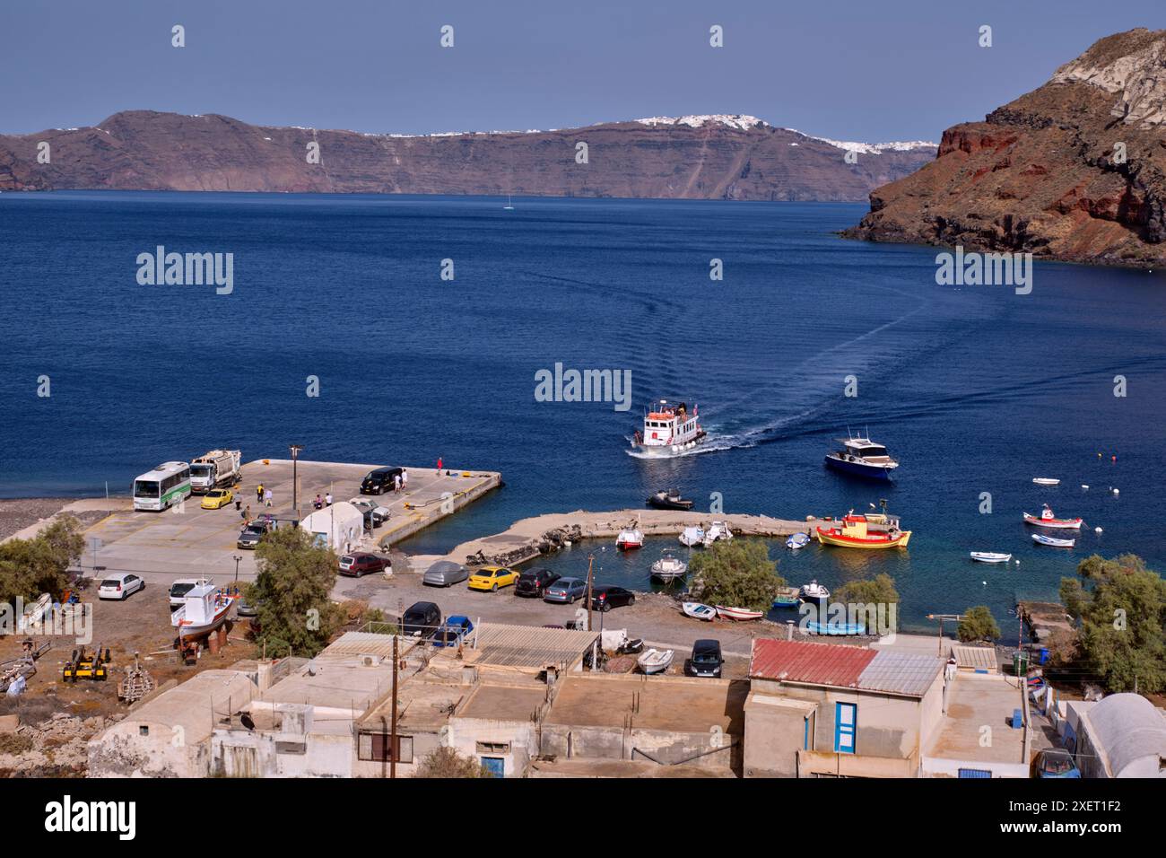 Traghetto in arrivo al porto di Riva, con Santorini in lontananza. Thirasia, Isole Cicladi, Grecia. Foto Stock