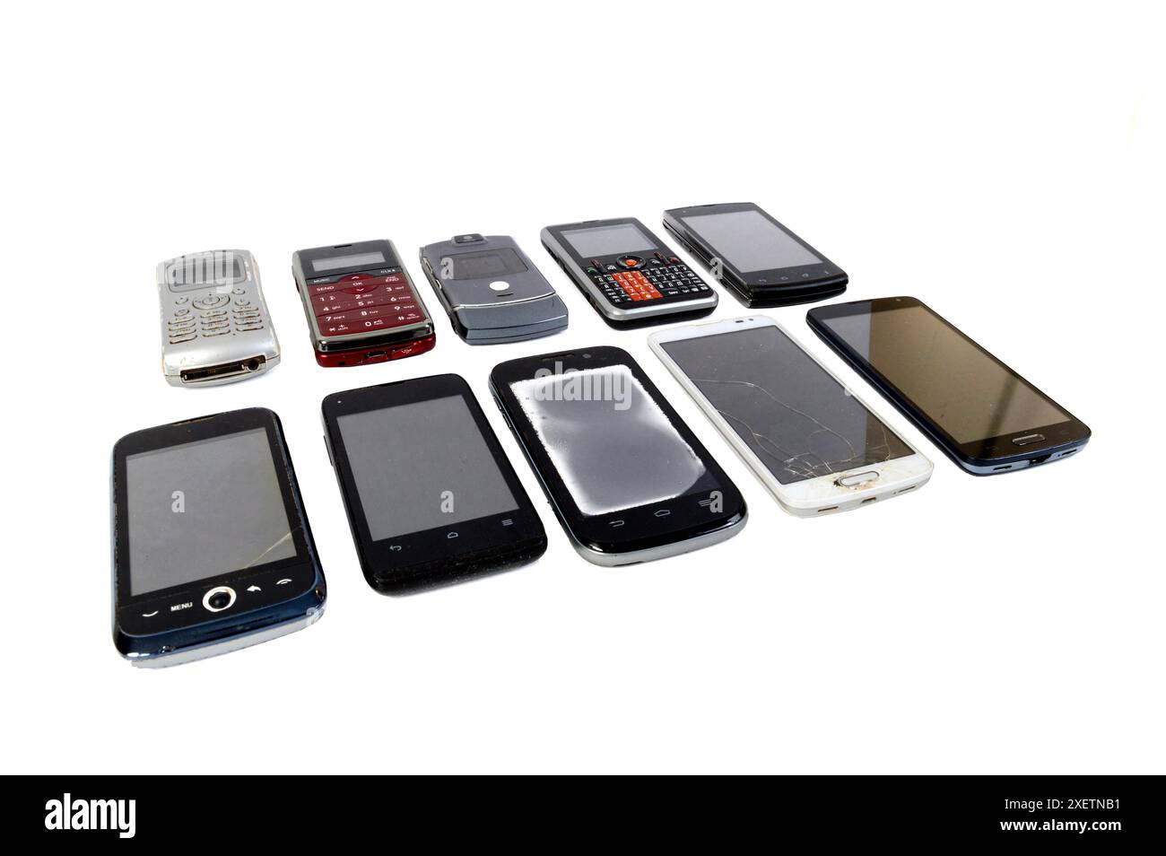 Foto in primo piano orizzontale di 10 telefoni di diverse generazioni su due file di cinque su sfondo bianco. Copia spazio. Foto Stock