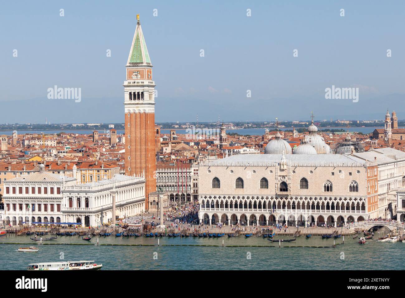 Vista sopraelevata o aerea del Palazzo dei Dogi, del Campanile di San Marco e della Biblioteca Marciana, Venezia, Italia con folle di turisti al tramonto dalla laguna Foto Stock