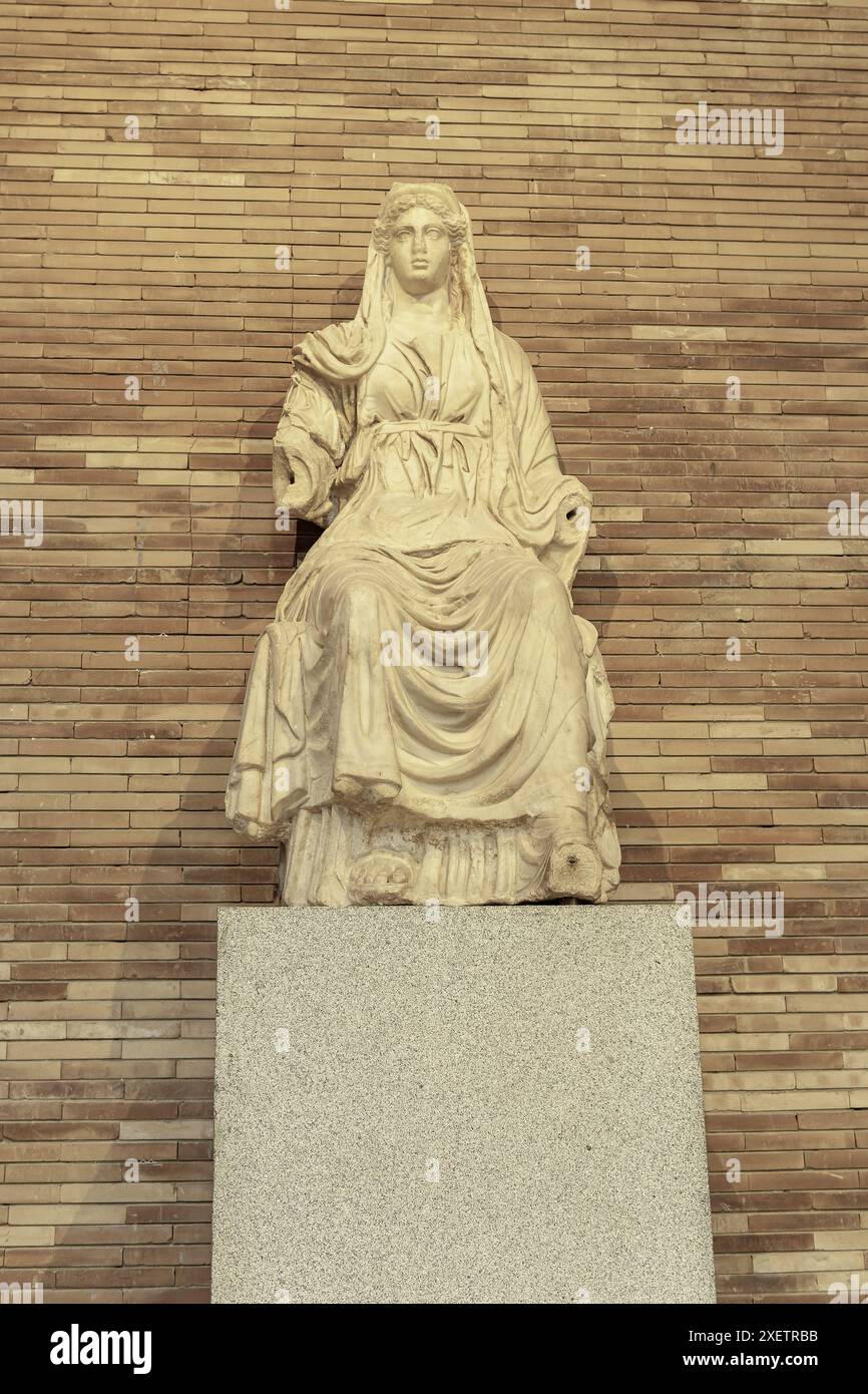 Antica statua in marmo della dea romana Cerere, seduta e drappeggiata in abiti classici. La scultura dettagliata enfatizza la sua espressione serena e Foto Stock