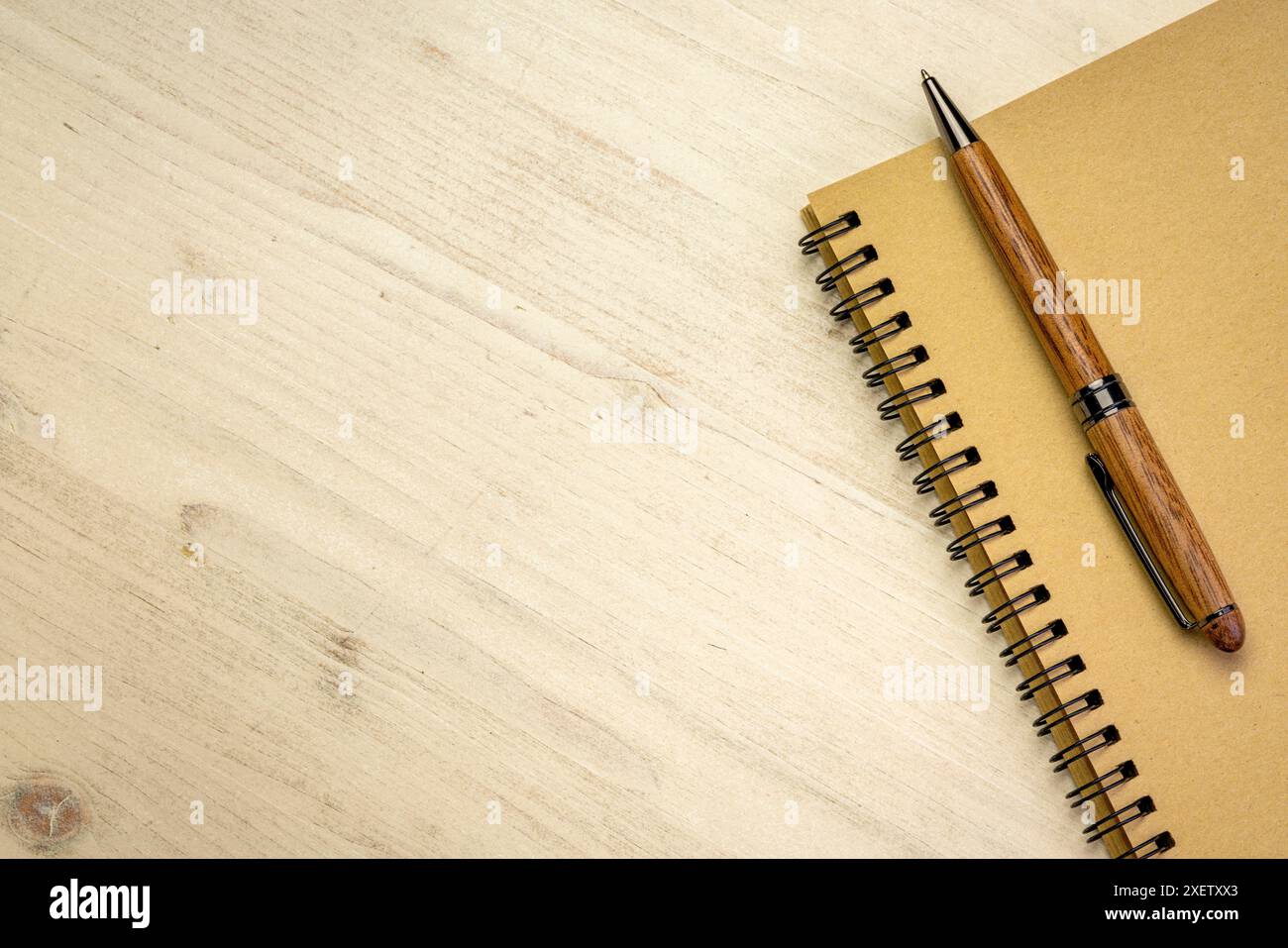 quaderno a spirale con penna su sfondo in legno angosciato e spazio per le copie Foto Stock