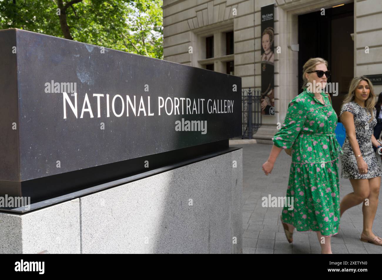Targa del nome della galleria nazionale di Londra, scritta bianca su ottone nero fuori dall'ingresso della galleria, con due donne che visitano il Regno Unito Foto Stock