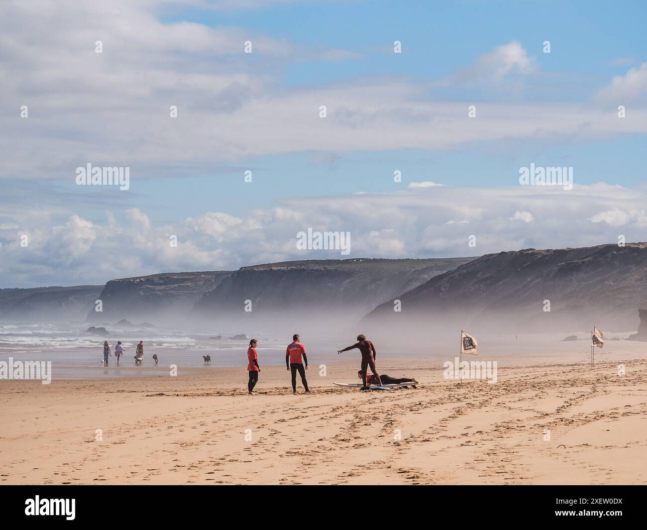 Praia da Bordeira, Portogallo; 26 giugno 2024: Istruttore della scuola di surf che insegna tecnica di decollo a uno studente di surf a Praia da Bordeira, Algarve, Portu Foto Stock