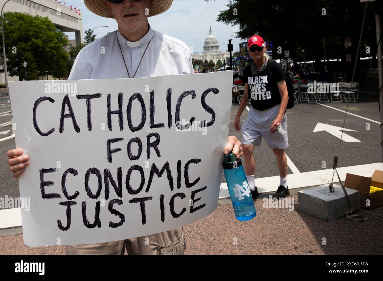 Washington DC, Stati Uniti. 29 giugno 2024. Un manifestante mostra un segno con le parole "cattolici per la giustizia economica" durante la marcia dei poveri su Pennsylvania Ave a Washington DC, USA, il 29 giugno 2024. La marcia richiede diritti economici e umani per i poveri americani di diversa provenienza. La campagna dei poveri è motivata dal desiderio di giustizia economica: L'idea che tutte le persone debbano avere ciò di cui hanno bisogno per vivere. Crediti: Aashish Kiphayet/Alamy Live News Foto Stock