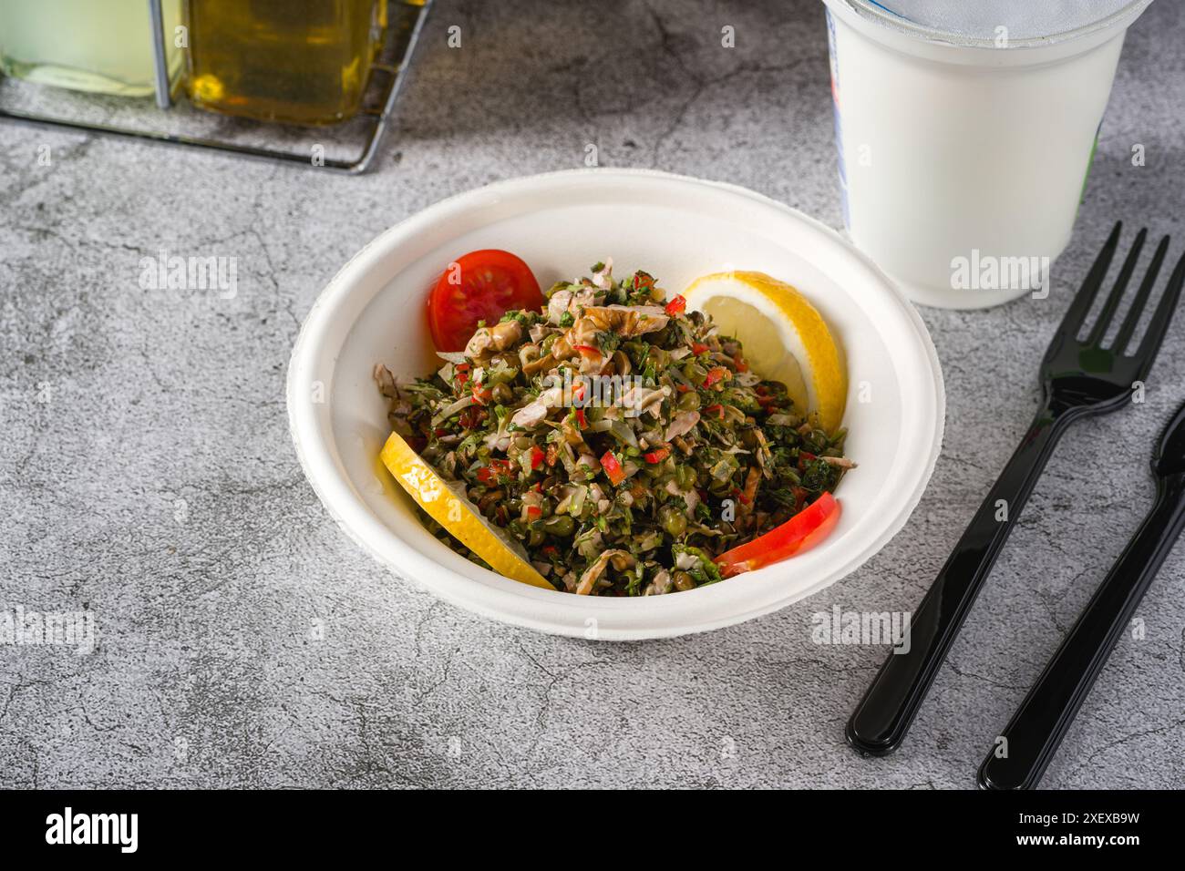 Insalata sana con quinoa, capperi e salmone in una ciotola nera Foto Stock