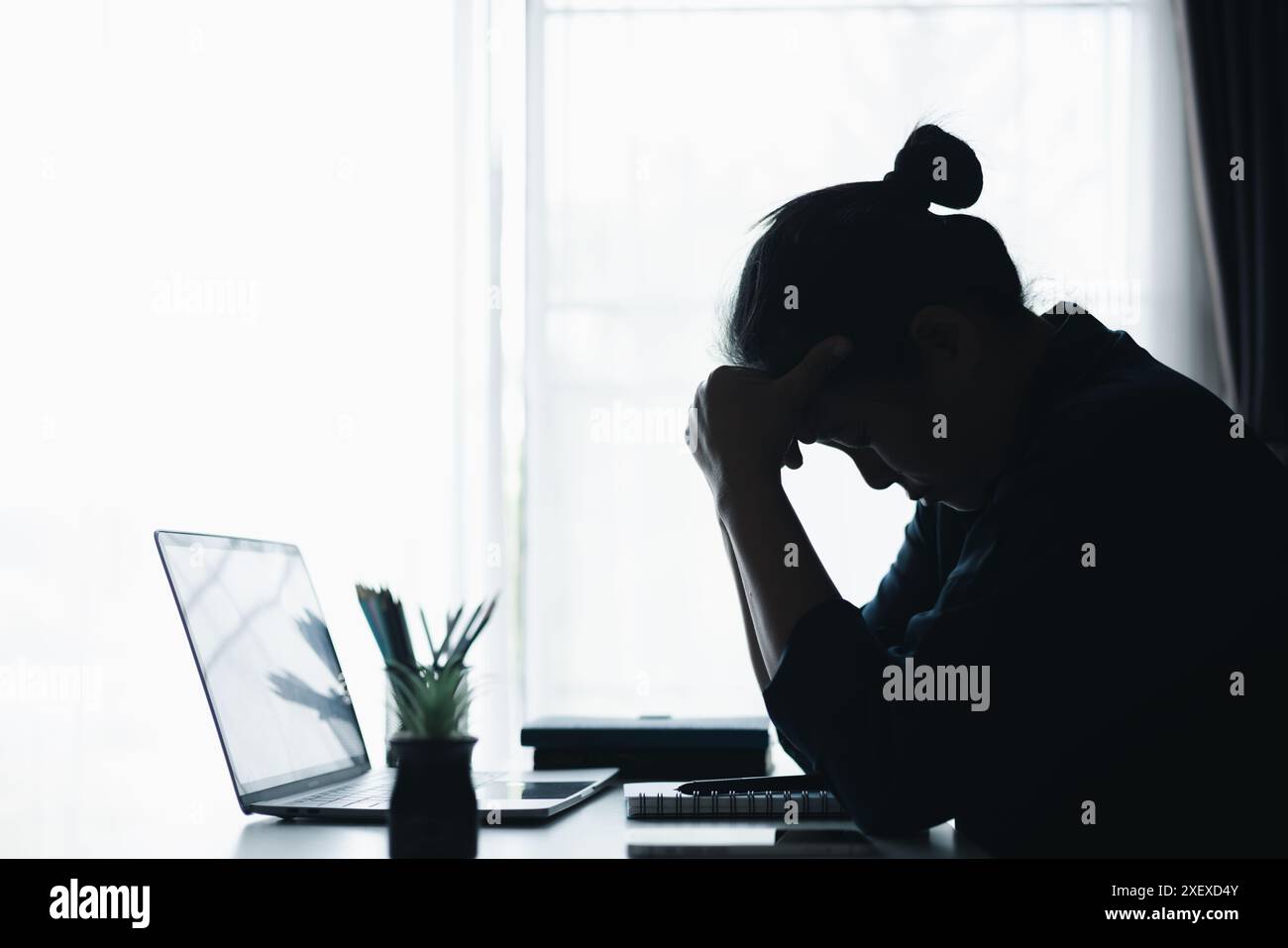 Una donna d'affari ha affrontato problemi difficili in ufficio, navigando lo stress sul lavoro e utilizzando il computer per trovare soluzioni in mezzo a sentimenti di depressione. prob Foto Stock