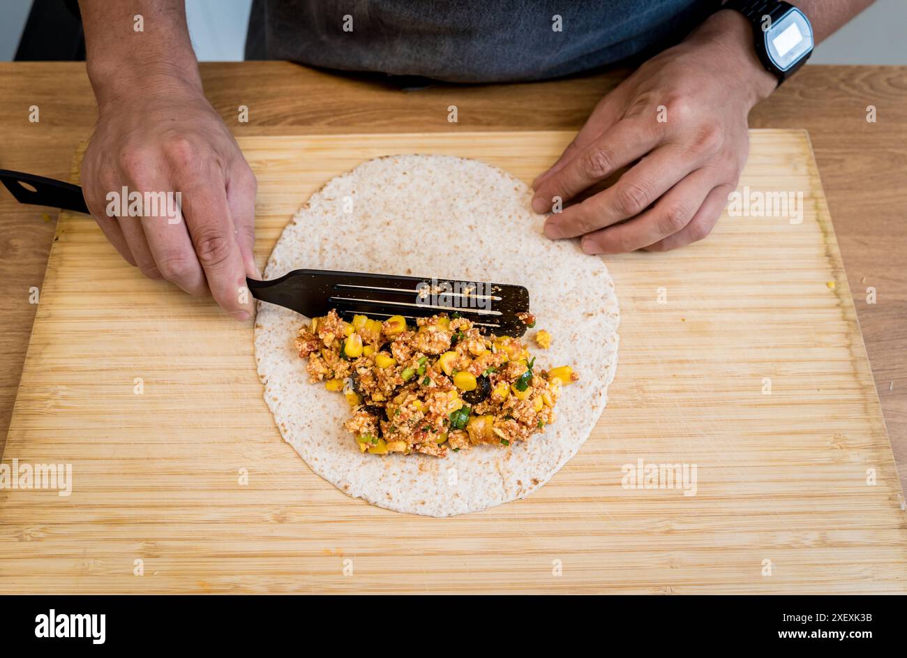 Lo chef della cucina prepara quesadillas con tofu e mais dolce Foto Stock