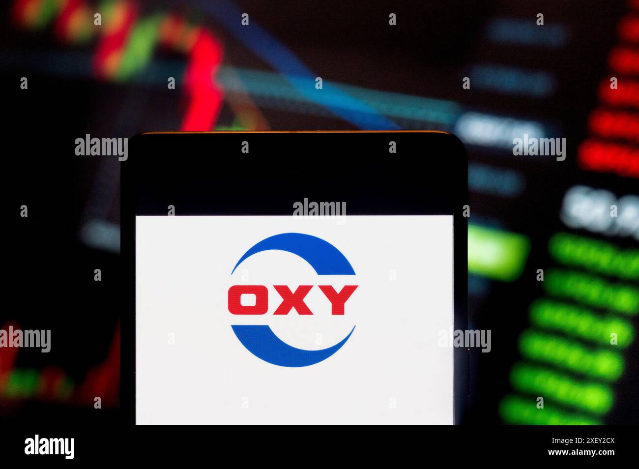 Cina. 23 giugno 2024. In questa illustrazione fotografica, la società americana impegnata nell'esplorazione di idrocarburi, Occidental Petroleum Corporation (OXY, NYSE: OXY), logo visualizzato su uno smartphone con un grafico indice di borsa economica sullo sfondo. Credito: SOPA Images Limited/Alamy Live News Foto Stock