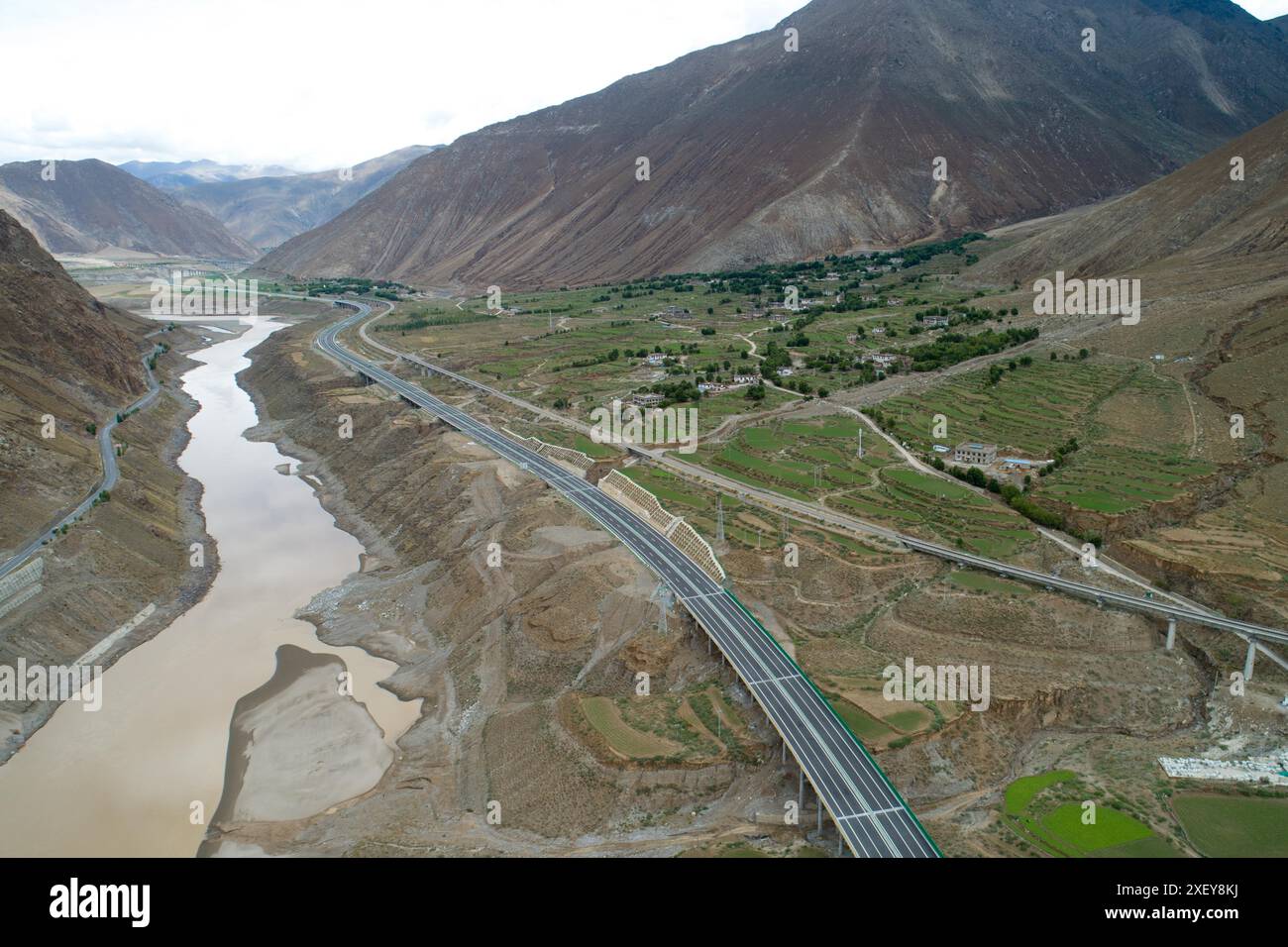 (240630) -- LHASA, 30 giugno 2024 (Xinhua) -- una foto di un drone aereo scattata il 27 giugno 2024 mostra una vista di un'autostrada di alta qualità che collega Lhasa e Xigaze nella regione autonoma di Xizang della Cina sud-occidentale. Un'autostrada di alta qualità che collega le due più grandi città della regione autonoma di Xizang del sud-ovest della Cina è stata ufficialmente aperta al traffico domenica, tagliando a metà i tempi di viaggio tra le città, ha detto il dipartimento dei trasporti regionali. L'autostrada, che collega la capitale regionale Lhasa e Xigaze, la seconda città più grande della regione, si estende per 245 km L'autostrada a quattro corsie riduce i tempi di percorrenza tra Lhasa e Xi Foto Stock