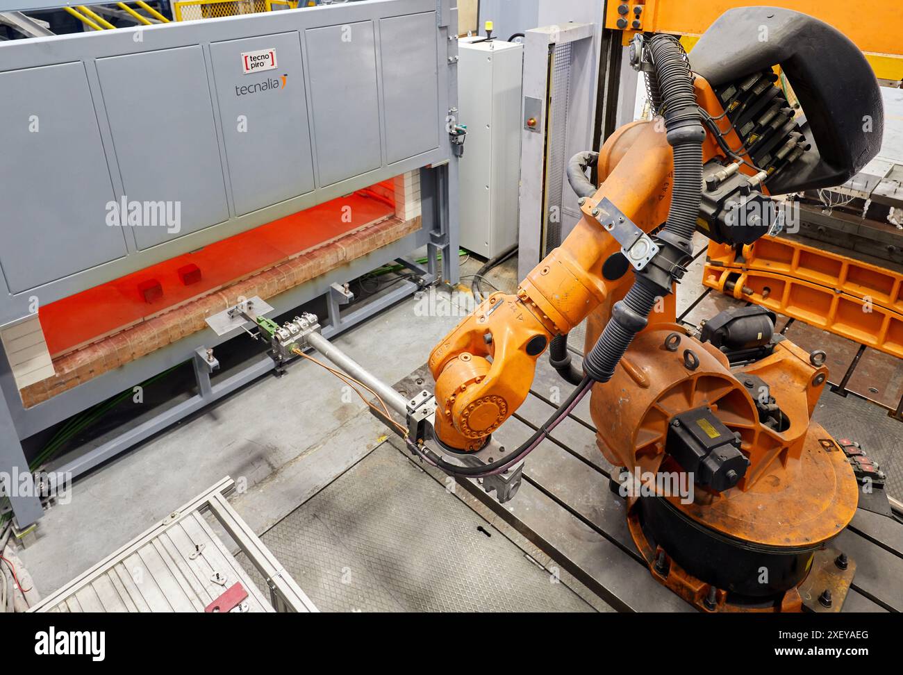 Robot che introduce i materiali nel forno e li porta successivamente alla pressa, alla cella di stampaggio a caldo, all'unità industriale, all'industria automobilistica, al centro tecnologico Foto Stock