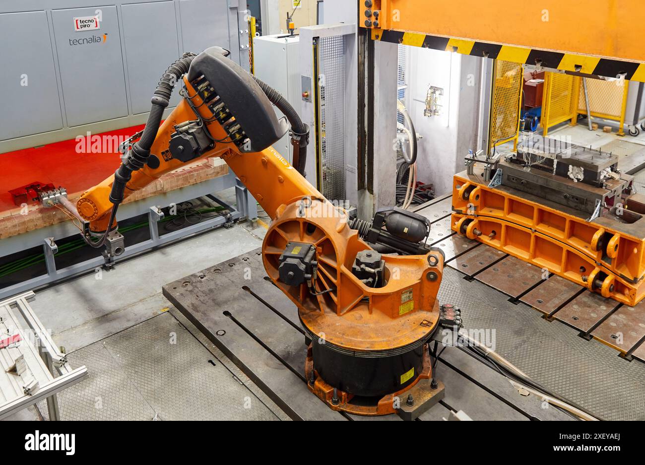 Robot che introduce i materiali nel forno e li porta successivamente alla pressa, alla cella di stampaggio a caldo, all'unità industriale, all'industria automobilistica, al centro tecnologico Foto Stock