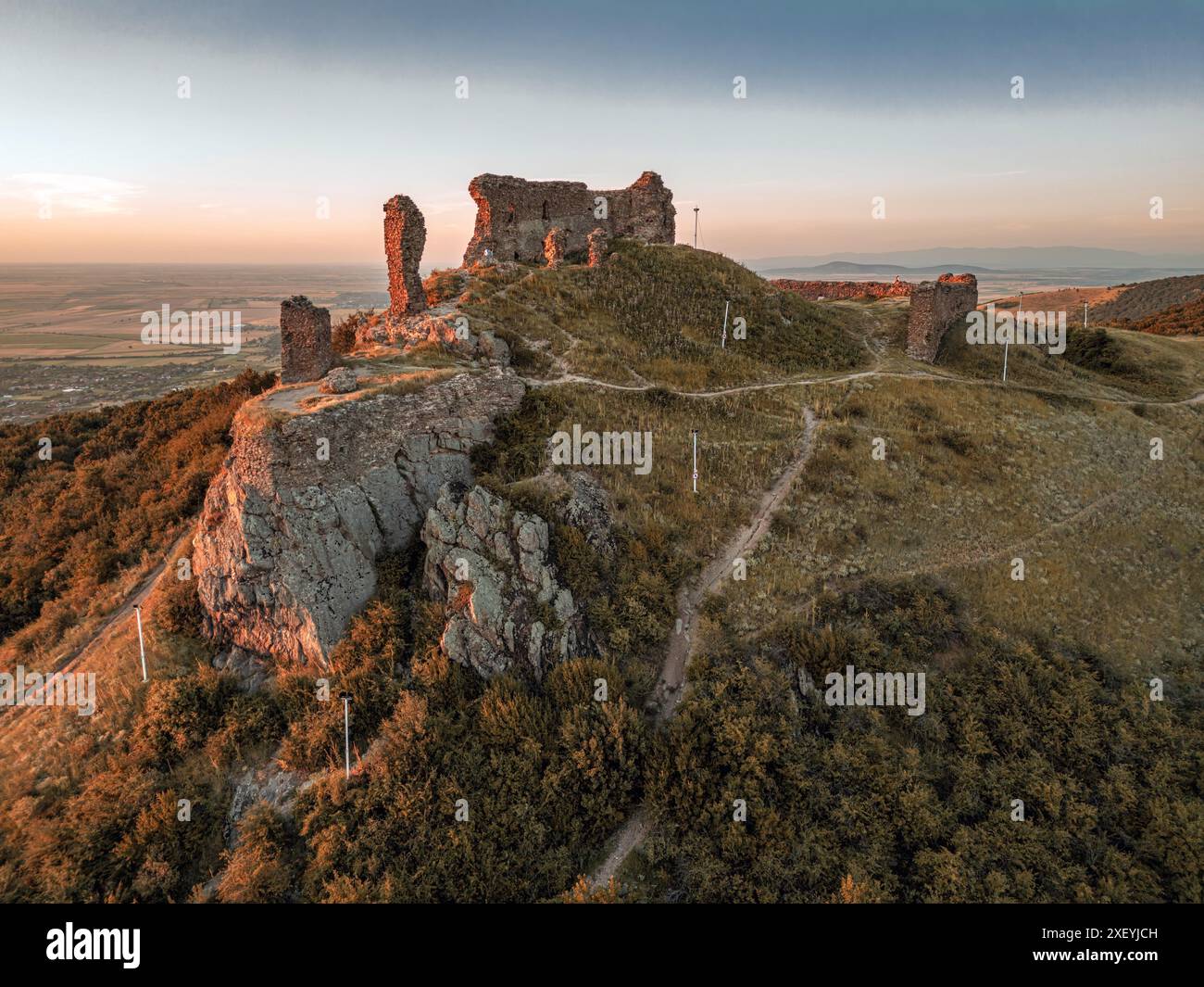 Le antiche rovine medievali della cittadella siriana viste durante l'ora d'oro. Foto scattata il 29 giugno 2024, contea di Arad, Romania. Foto Stock