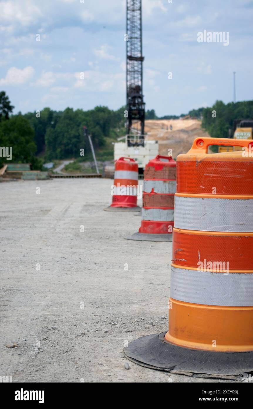 Botti di traffico di fronte a una gru in un cantiere Foto Stock