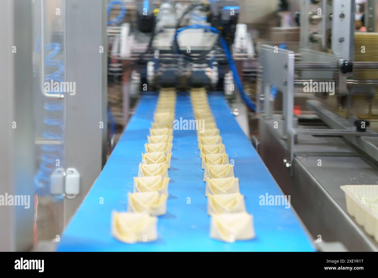 macchina per piegare gli scarichi automatici in azione, un'innovazione fondamentale nella produzione e nella lavorazione degli alimenti Foto Stock