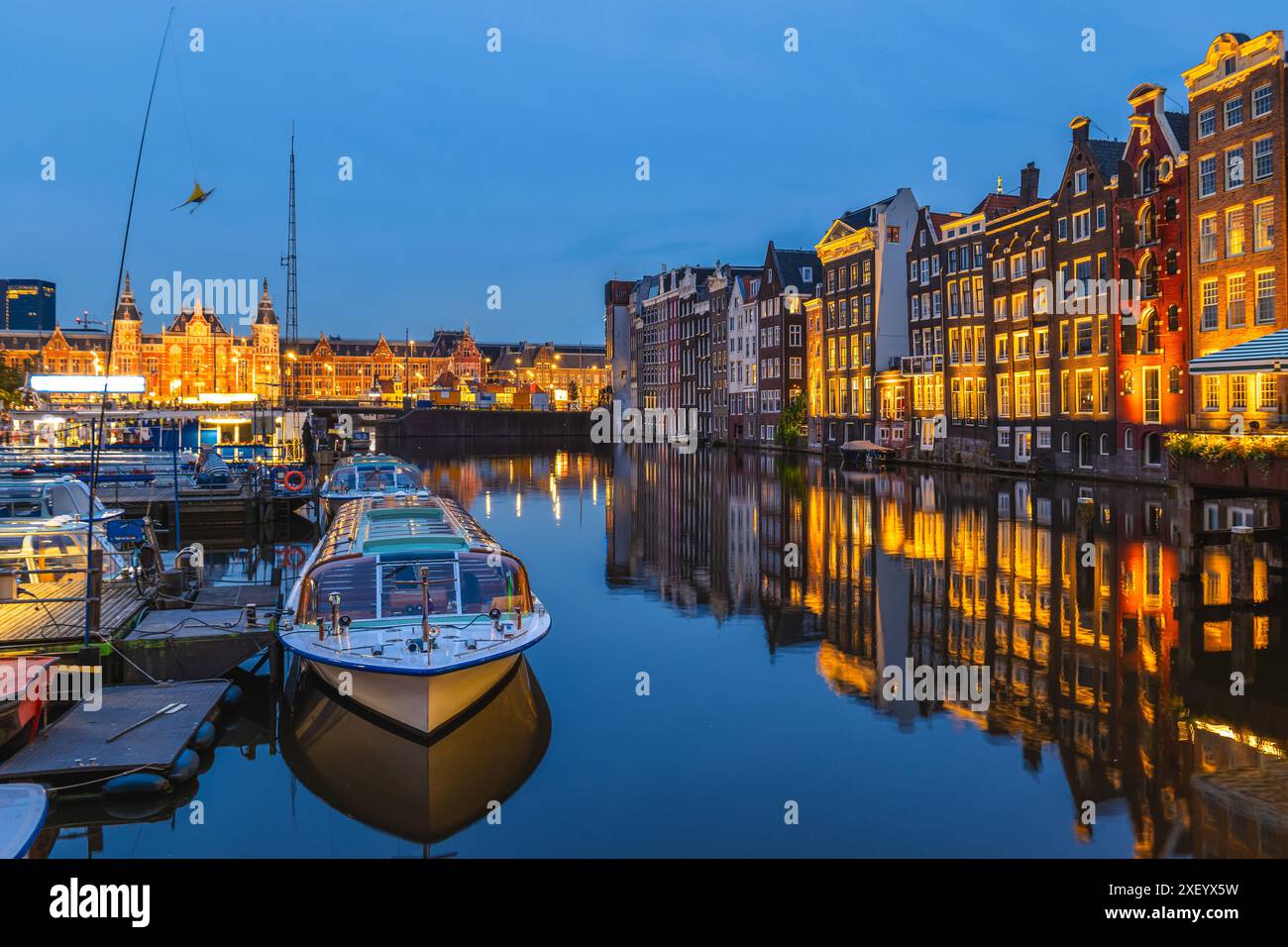 Scenario di Damrak ad Amsterdam, olandese. Le case si trovano direttamente sull'acqua Foto Stock