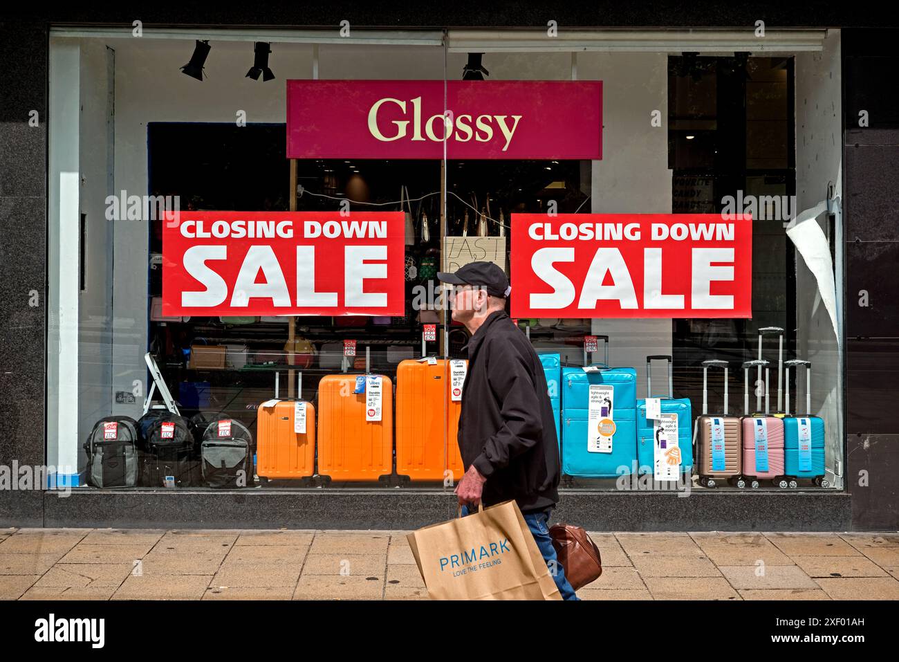 Uomo che cammina accanto ai cartelli "Closing Down sale" in una vetrina di Princes Street, Edimburgo, Scozia, Regno Unito. Foto Stock