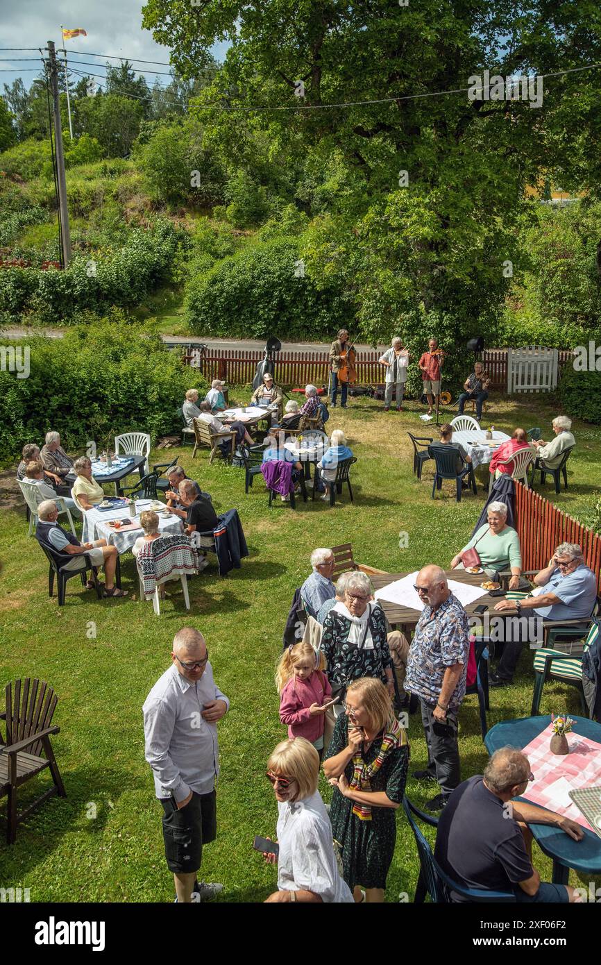 Festa in giardino nel villaggio con musicisti folk che suonano in sottofondo. Mellosa, Flen, Svezia Foto Stock