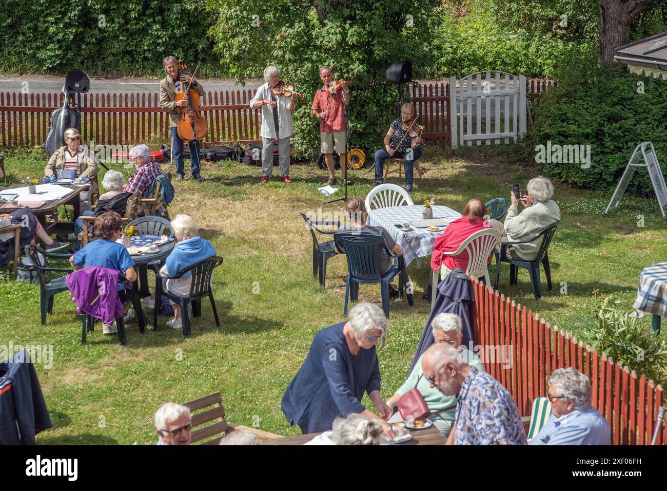 Festa in giardino nel villaggio con musicisti folk che suonano in sottofondo. Mellosa, Flen, Svezia Foto Stock