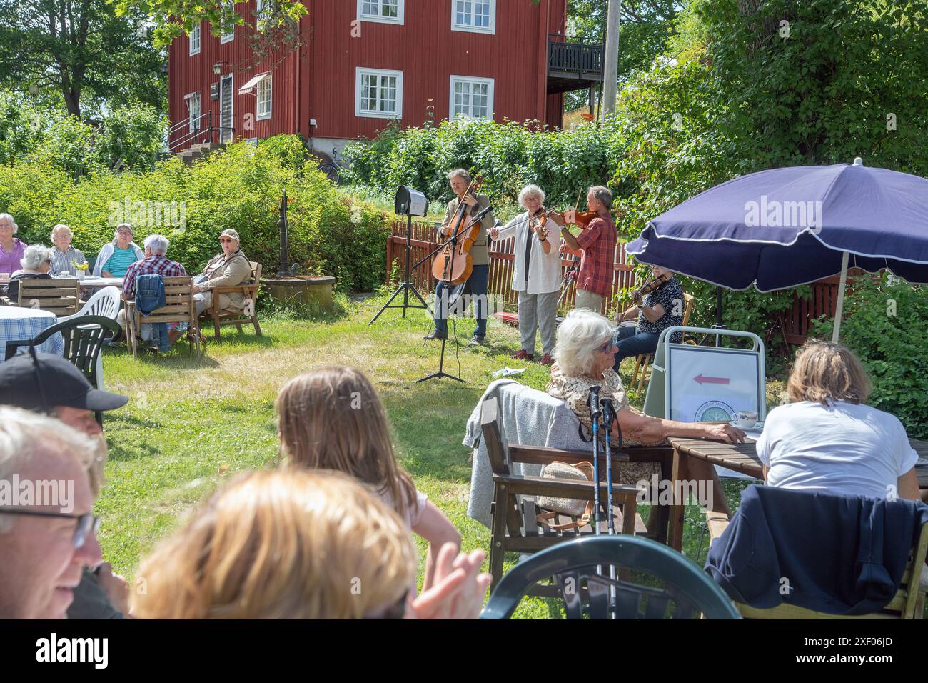 Festa in giardino nel villaggio con musicisti folk che suonano in sottofondo. Mellosa, Flen, Svezia Foto Stock
