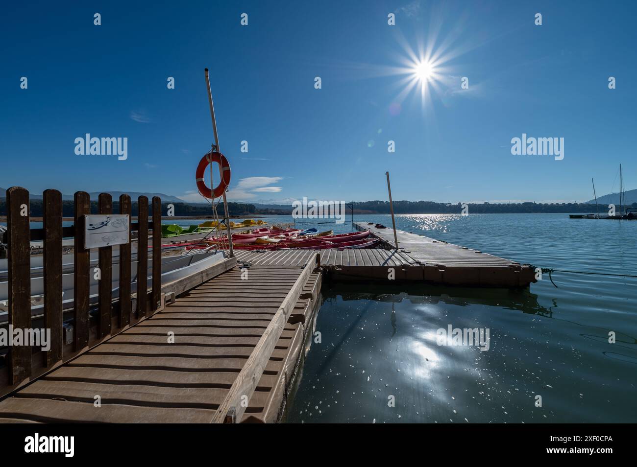 Foto grandangolare di un molo con canoe e kayak su un bacino idrico di Granada in una soleggiata mattinata d'inverno Foto Stock