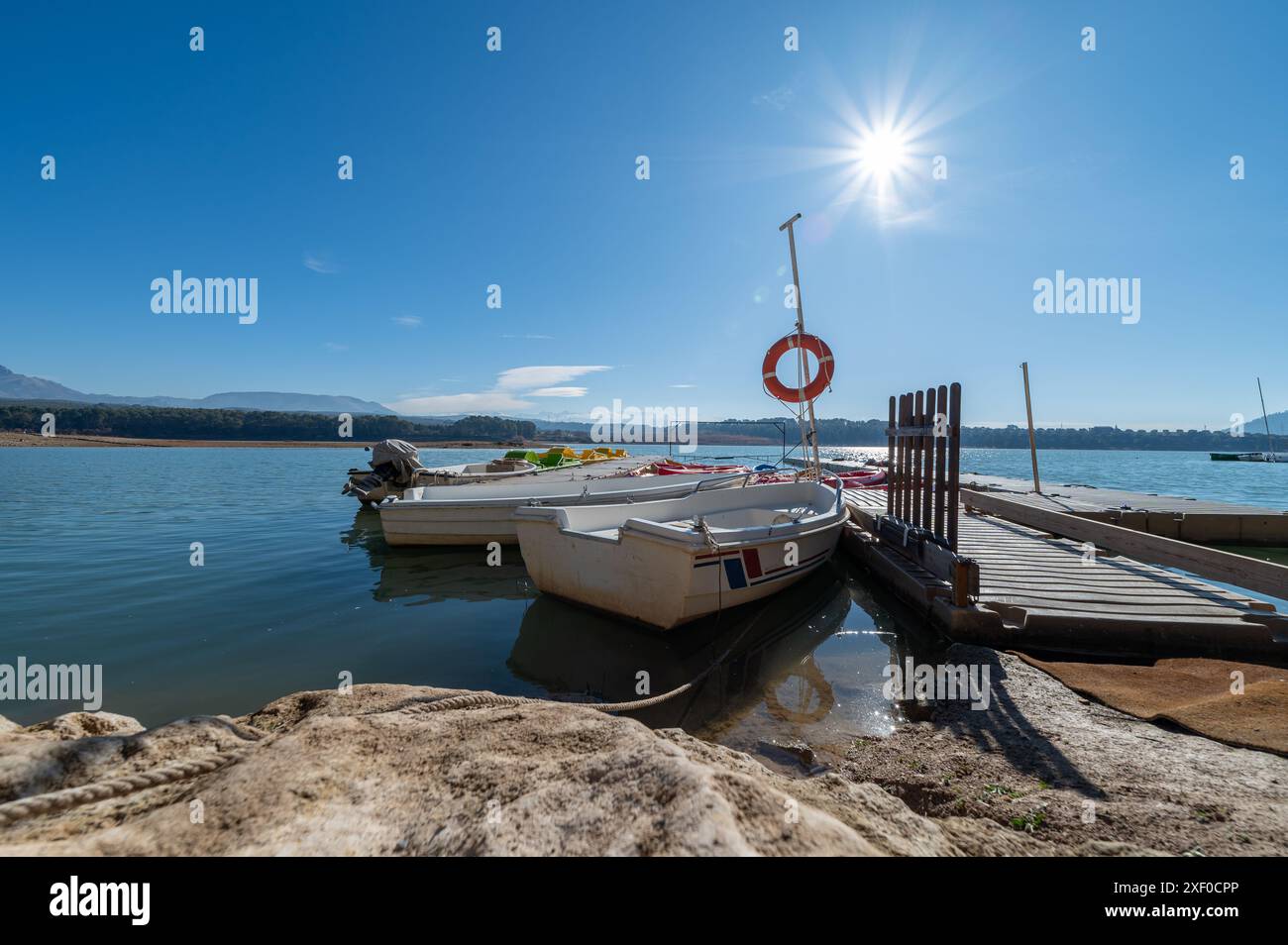 Foto grandangolare di un molo con canoe e kayak su un bacino idrico di Granada in una soleggiata mattinata d'inverno Foto Stock