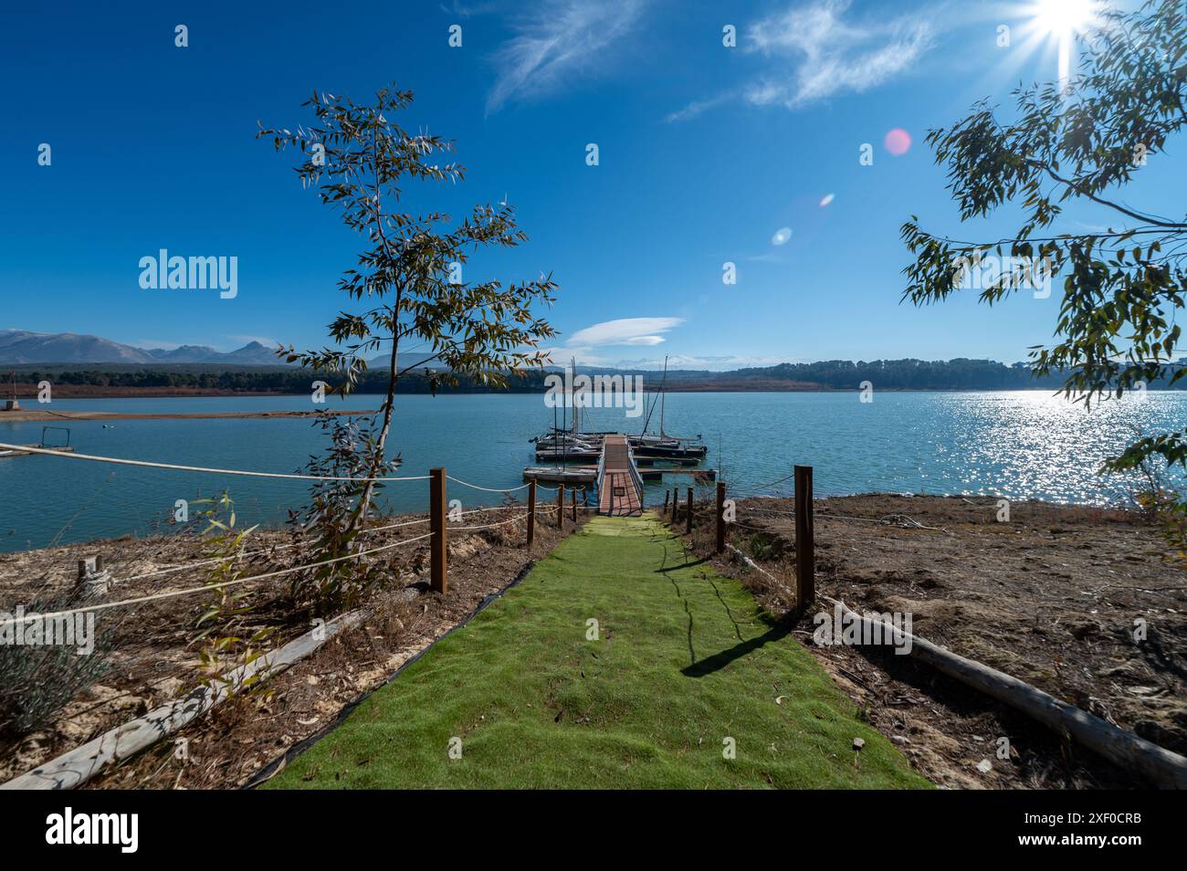 Foto grandangolare di un molo con canoe e kayak su un bacino idrico di Granada in una soleggiata mattinata d'inverno Foto Stock