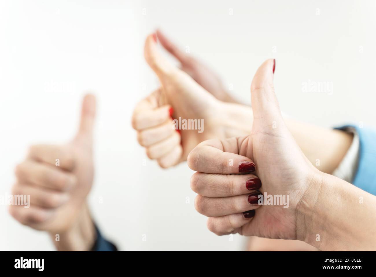 Primo piano dei membri del team che danno un gesto con il pollice in alto. Approvazione aziendale e feedback positivo in un ambiente aziendale. Celebrazione del successo in Foto Stock