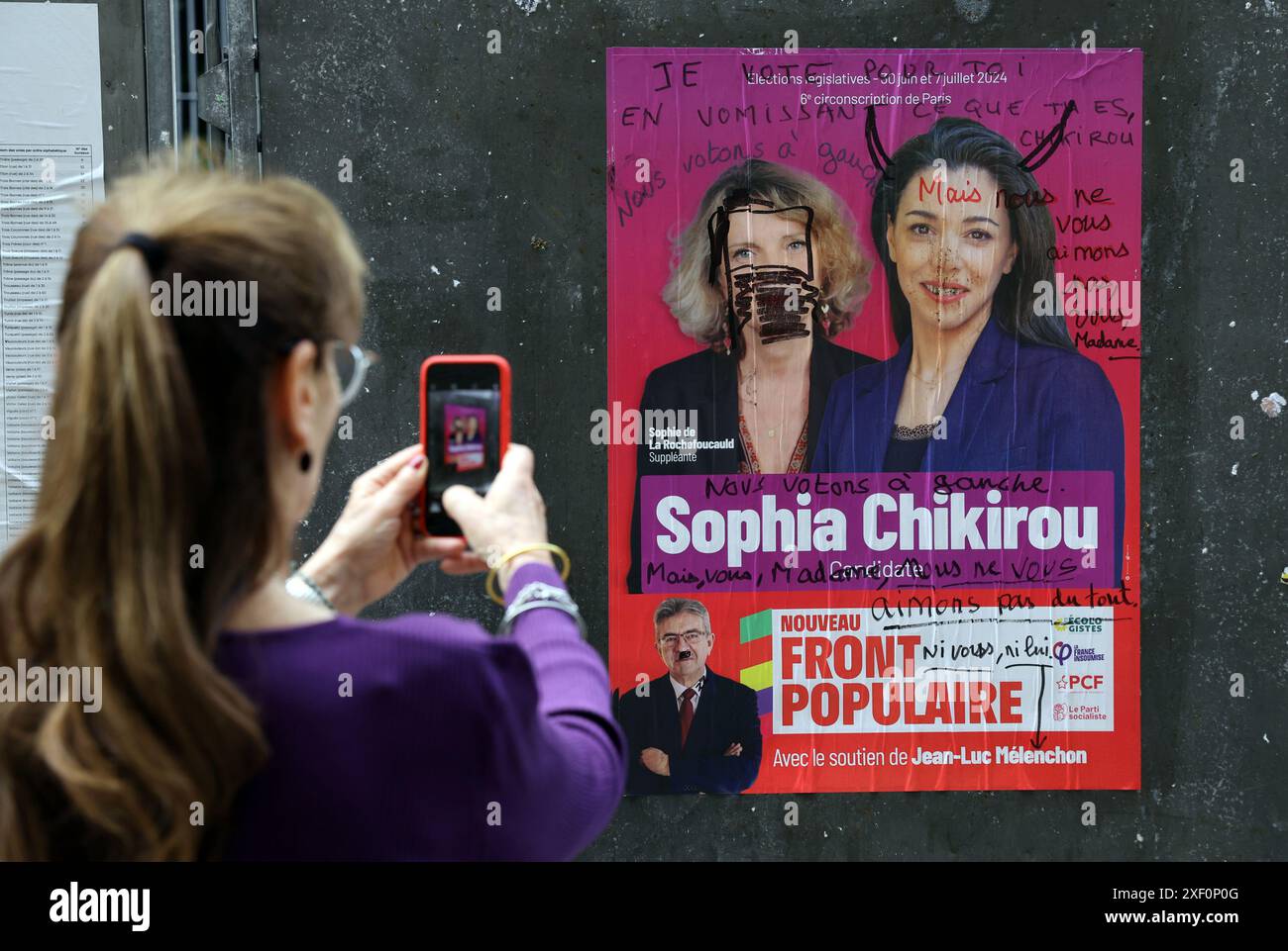 Parigi, Francia. 30 giugno 2024. Una donna passa davanti a un manifesto della campagna elettorale della nuova alleanza di sinistra, Nouveau Front Populaire NFP (nuovo fronte Popolare), di fronte a una postazione elettorale durante il primo turno delle elezioni parlamentari a Parigi, in Francia, domenica 30 giugno 2024. I sondaggi suggeriscono che il Presidente francese Emmanuel Macron si troverà di fronte a un parlamento ostile, dominato da due blocchi radicali, l'estrema destra e l'estrema sinistra. Foto di Maya Vidon-White/UPI credito: UPI/Alamy Live News Foto Stock