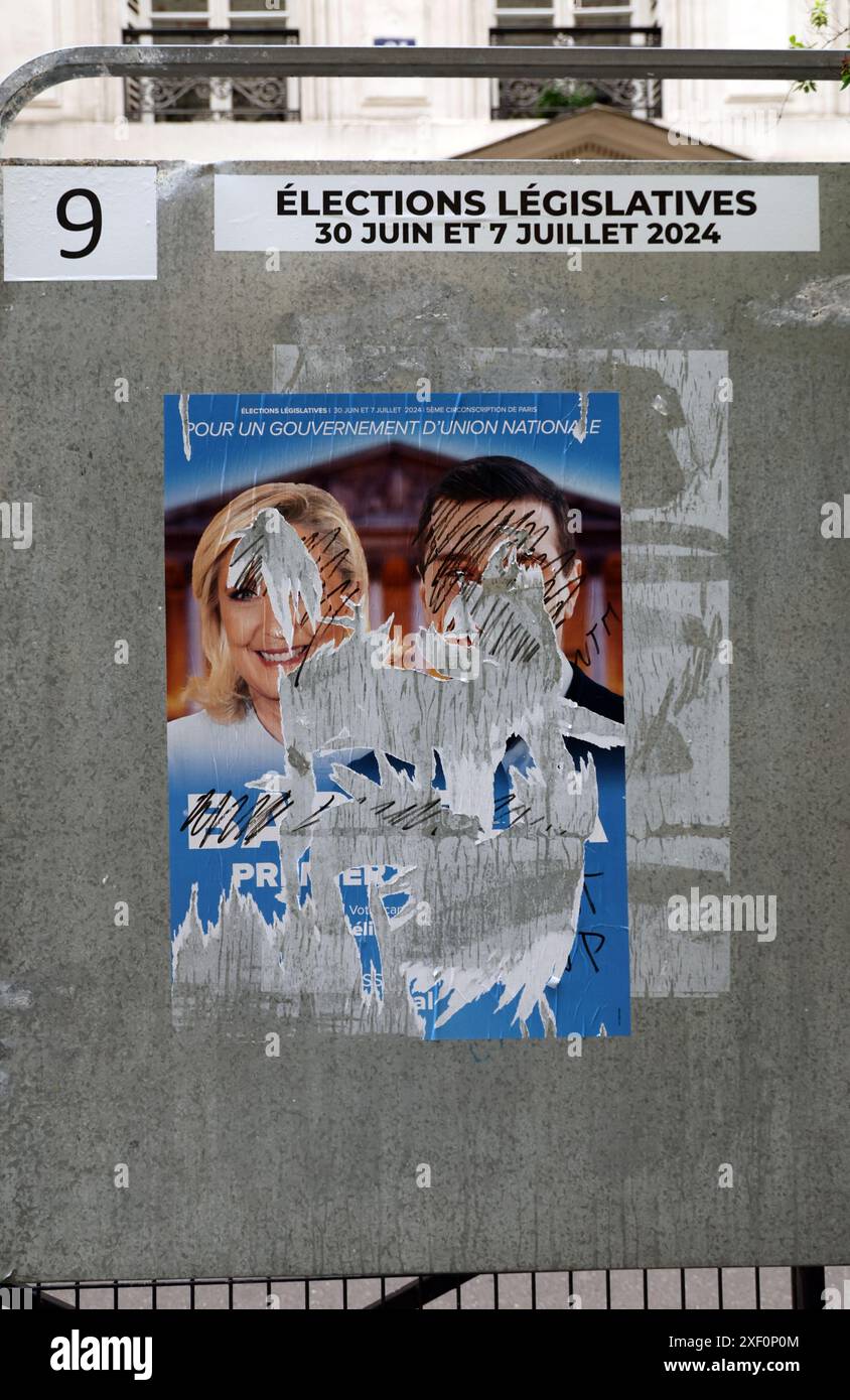 Parigi, Francia. 30 giugno 2024. Un deturpato manifesto della campagna del Rassemblement National di estrema destra (Rally Nazionale), mostra il leader del partito Marine le Pen (L) e il suo protetto di 28 anni, Jordan Bardella, di fronte a una stazione elettorale durante il primo turno delle elezioni parlamentari a Parigi, in Francia, domenica 30 giugno 2024. Il paese diviso sta votando in elezioni anticipate ad alta quota che potrebbero vedere il partito di estrema destra impadronirsi del potere in una prima storica. Foto di Maya Vidon-White/UPI credito: UPI/Alamy Live News Foto Stock