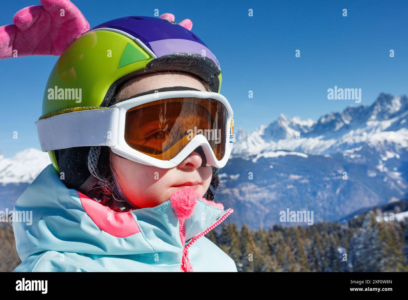 Ritratto del bambino con attrezzatura da sci colorata e divertente casco con ali Foto Stock