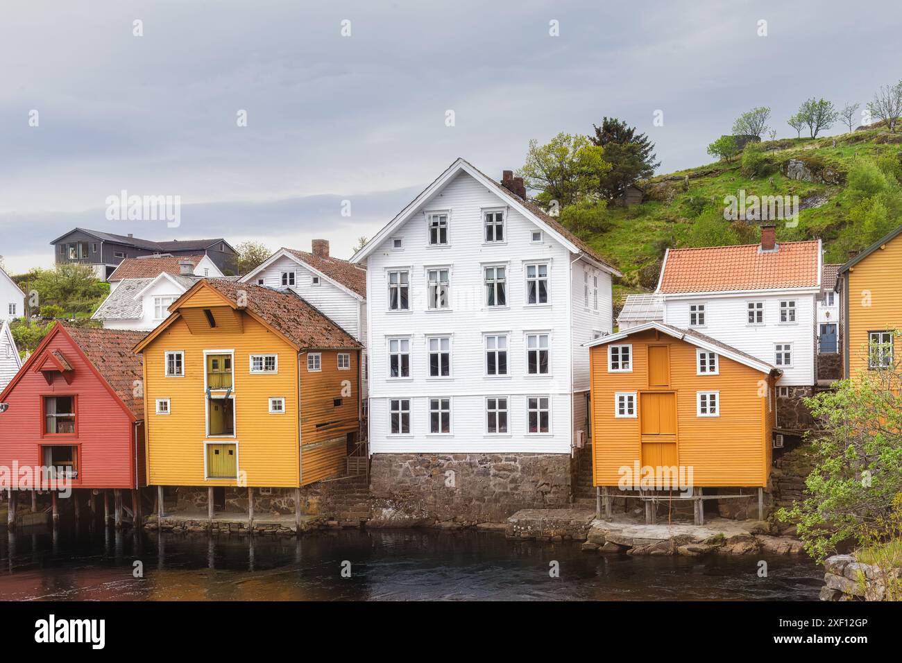 Tradizionali edifici in legno dipinti in vivaci sfumature, lungo il fiume, che creano un'atmosfera pittoresca e affascinante. Sogndalstrand, Norvegia Foto Stock