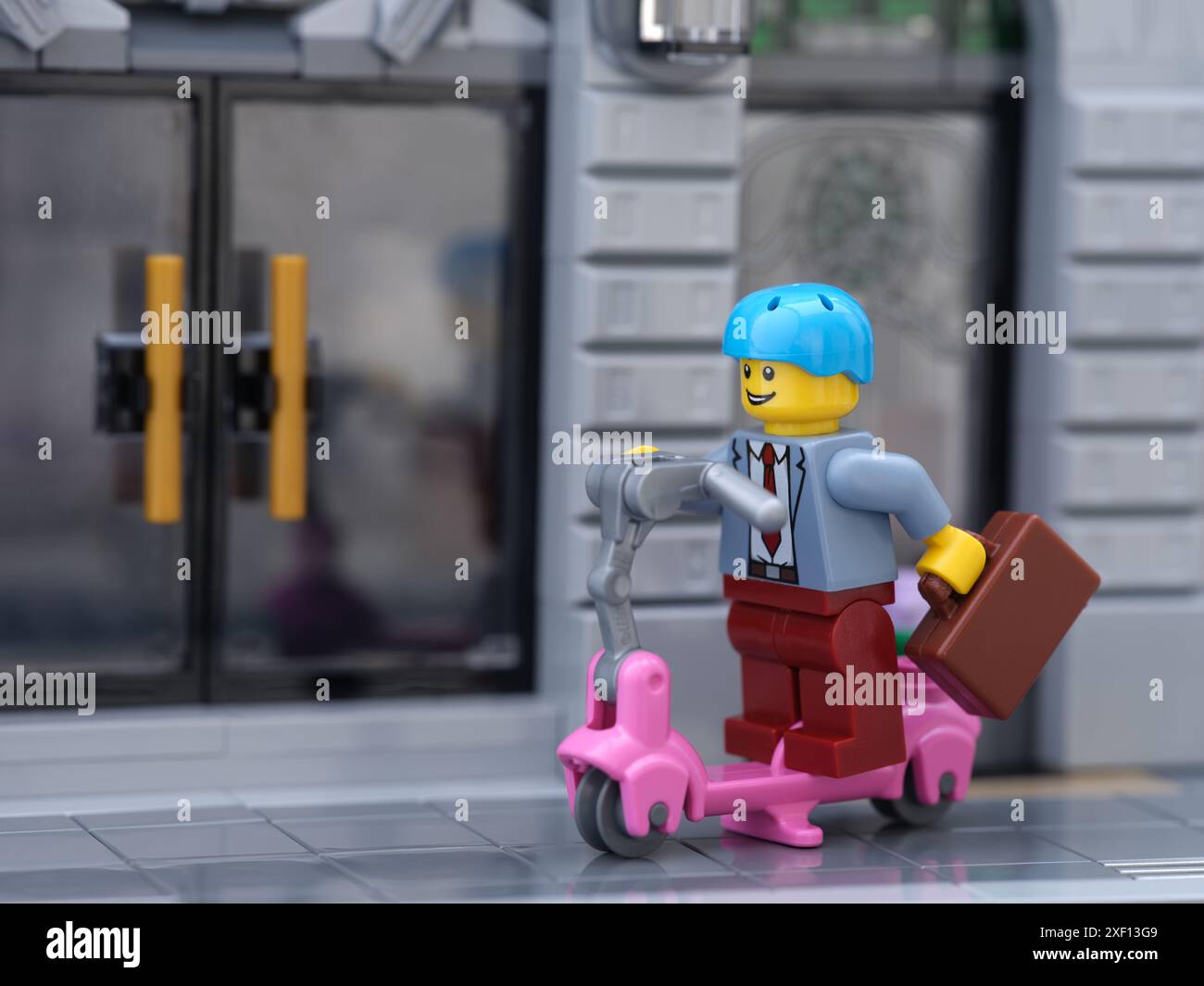 Tambov, Federazione Russa - 30 giugno 2024 Una minifigura d'affari Lego che viaggia in scooter. Primo piano. Foto Stock