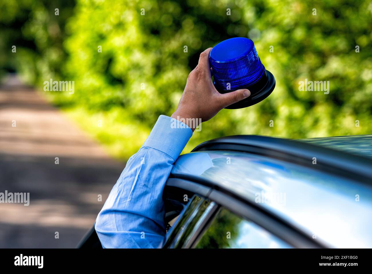 luce blu lampeggiante su un'auto della polizia durante una guida con luce blu Foto Stock