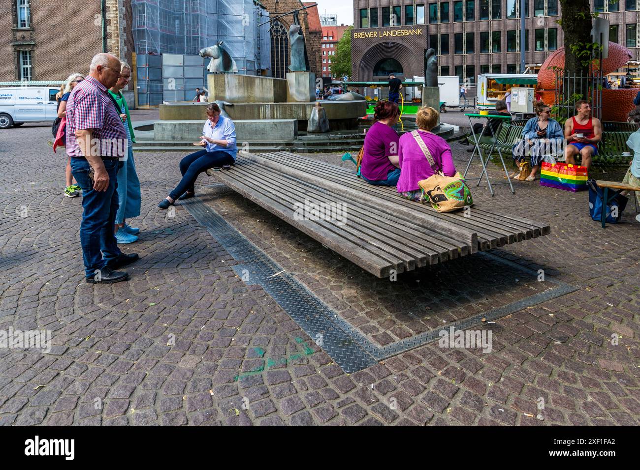 Questa panchina nel cortile della cattedrale di Brema è anche un'uscita di emergenza per il Ratskeller di 5.000 metri quadrati. Viene emesso un segnale acustico prima dell'apertura, dopodiché il banco si ripiega lateralmente. Oltre 12.000 ospiti all'anno sono ora guidati attraverso il sito di Brema Ratskeller, patrimonio dell'umanità. Panchina sulla piazza del mercato presso il municipio di Brema. L'uscita di emergenza del Ratskeller di Brema si trova sotto questa panca ripiegabile. Brema, Germania Foto Stock