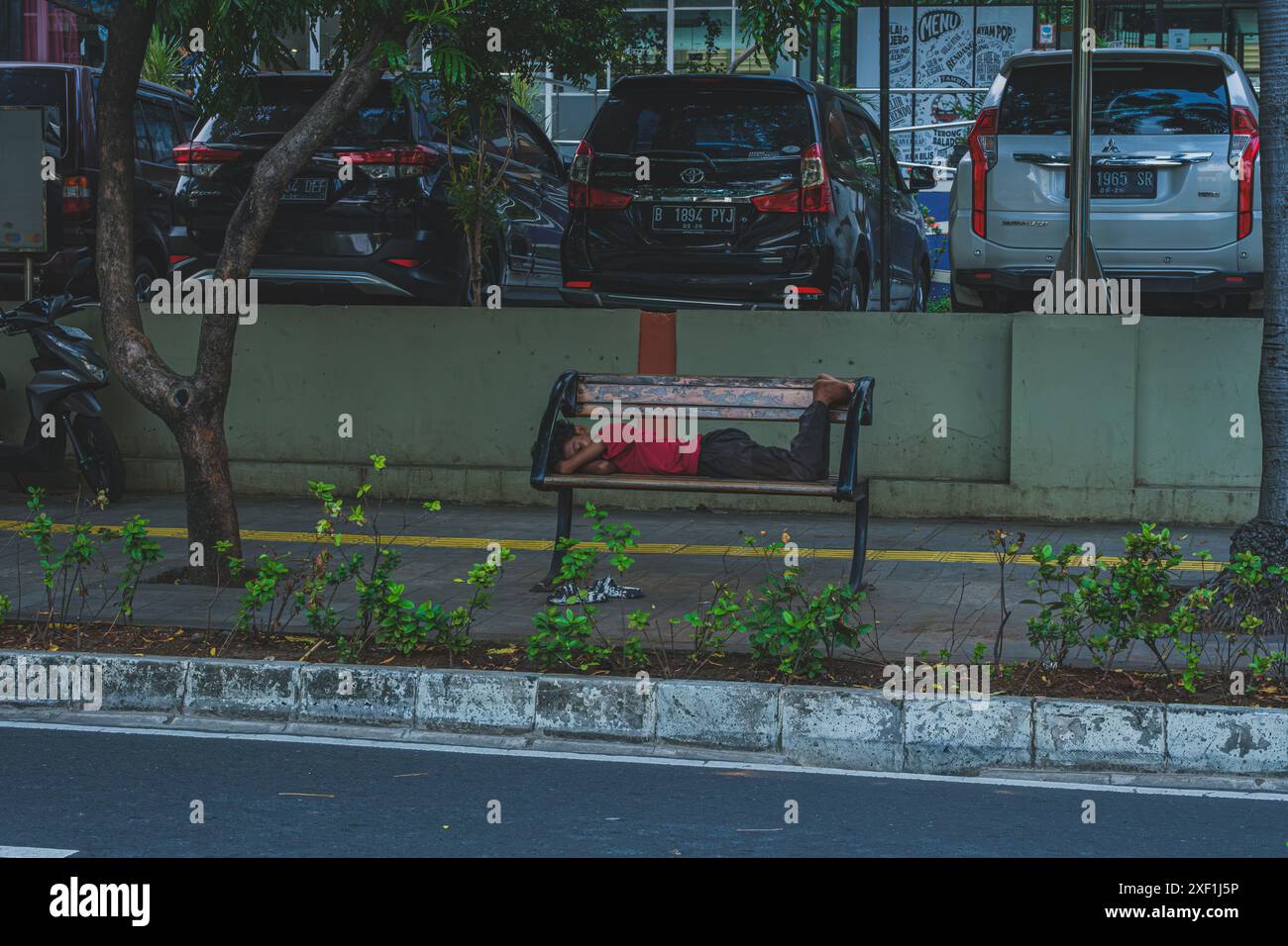 Giacarta, Indonesia - 11 maggio 2024. il ragazzo sta dormendo vicino al parcheggio dell'ufficio. Foto Stock