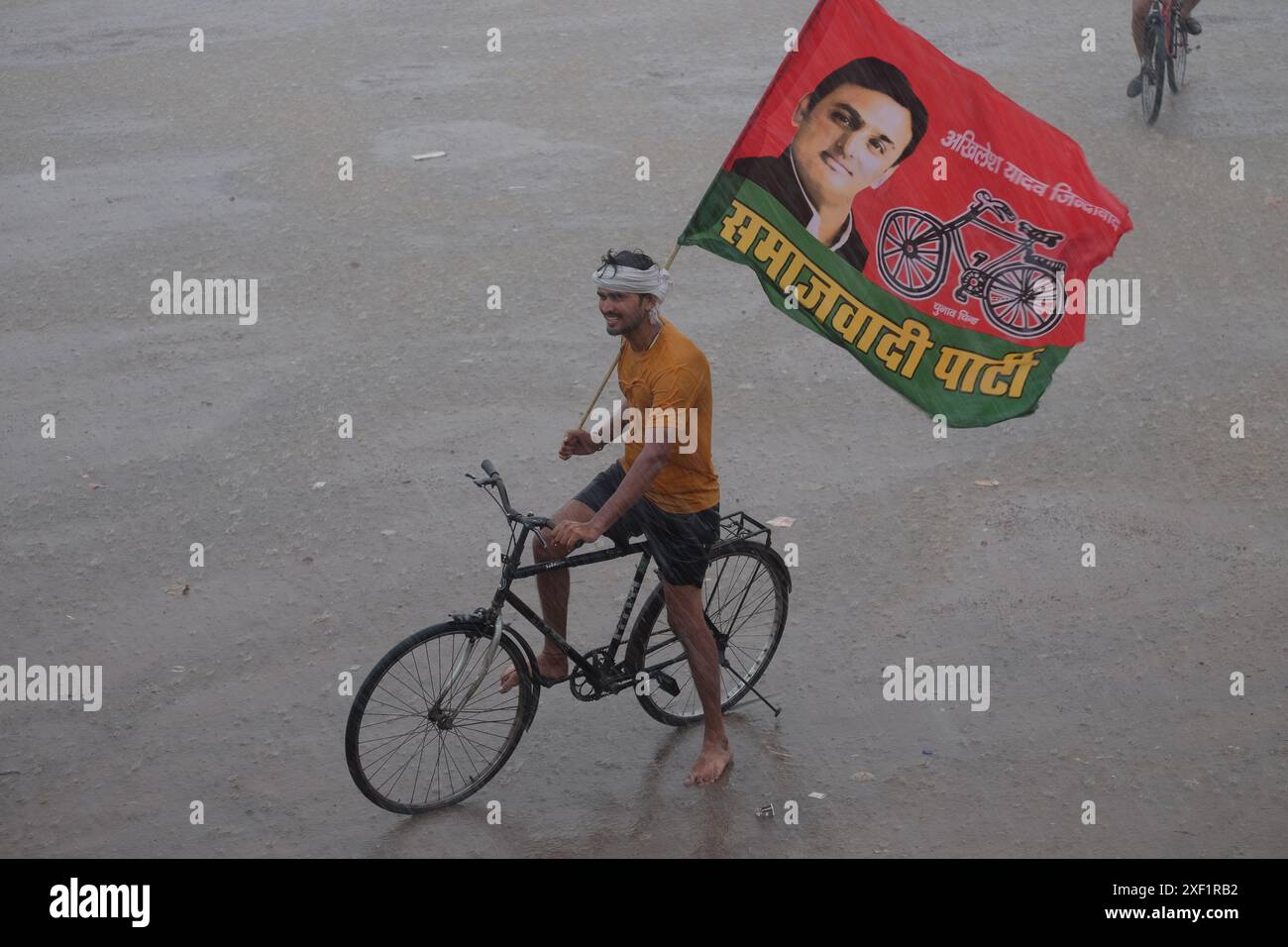 Prayagraj, Uttar Pradesh, India. 30 giugno 2024. Il presidente nazionale del partito Samjwadi Lohia Abhishek Yadav ospita l'evento con più di 5100 bandiere per celebrare il 51° compleanno nel distretto di Prayagraj. Nonostante tutti i preparativi siano rovinati a causa della pioggia, tutti questi giovani stanno lavorando duramente e diligentemente per rendere speciale il compleanno del loro leader. (Credit Image: © Shashi Sharma/Pacific Press via ZUMA Press Wire) SOLO PER USO EDITORIALE! Non per USO commerciale! Foto Stock