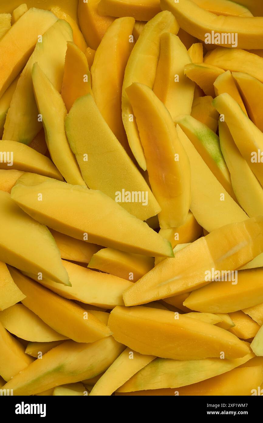 pezzi a fette di mango maturo sbucciato per vari usi culinari, mucchio di frutta tropicale rimossa per dessert insalate chutney frullati Foto Stock