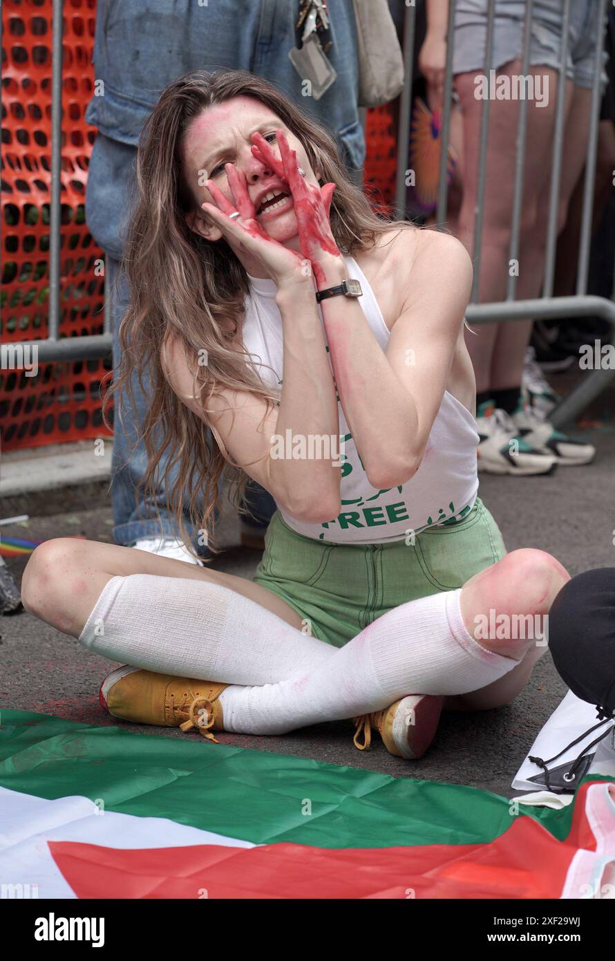 New York, Stati Uniti. 30 giugno 2024. Una donna protesta per la Palestina siede con altri seveerali per bloccare la strada durante la parata annuale del Pride . Il tema dell'anno era "Reflect, Empower and Unite". Credito: SOPA Images Limited/Alamy Live News Foto Stock