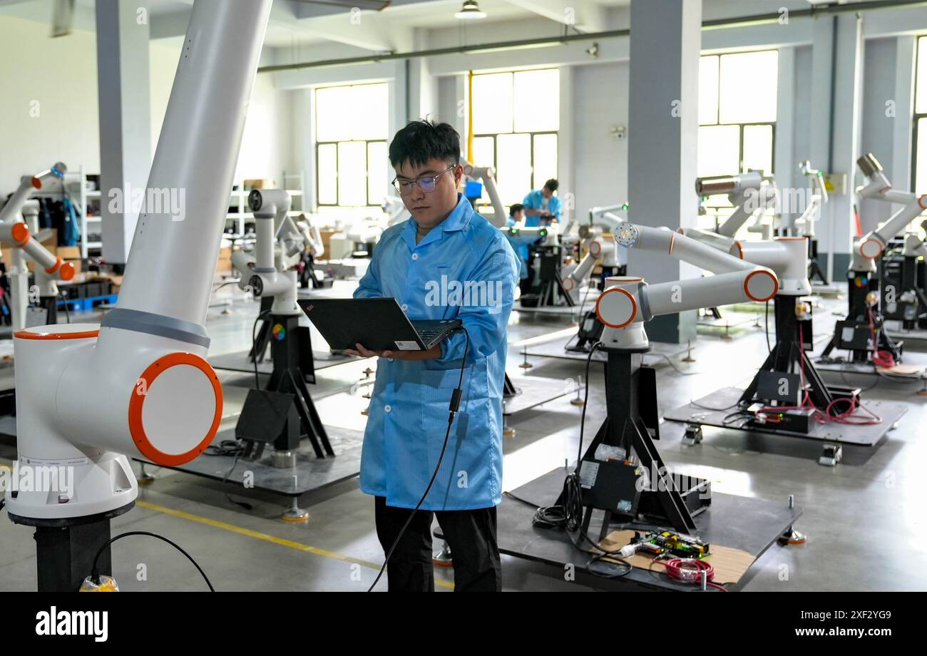 Jinan, la provincia cinese di Shandong. 12 maggio 2024. Un tecnico adegua i robot in un'officina a Zibo City, nella provincia di Shandong nella Cina orientale, 12 maggio 2024. Crediti: Yang Mingchao/Xinhua/Alamy Live News Foto Stock