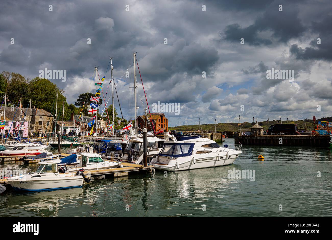 Nuvole tempestose sulle barche ormeggiate nel porto di Padstow, un grazioso villaggio costiero sulla costa settentrionale della Cornovaglia, in Inghilterra Foto Stock