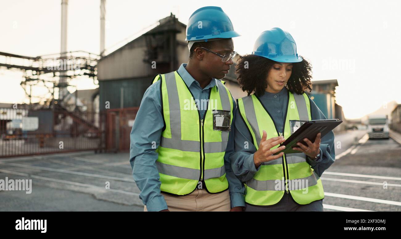 Industriale, outdoor e colleghi con tablet nella logistica per ispezioni, controlli dell'inventario o tempi di consegna. Spedizione, donna nera e uomo per Foto Stock