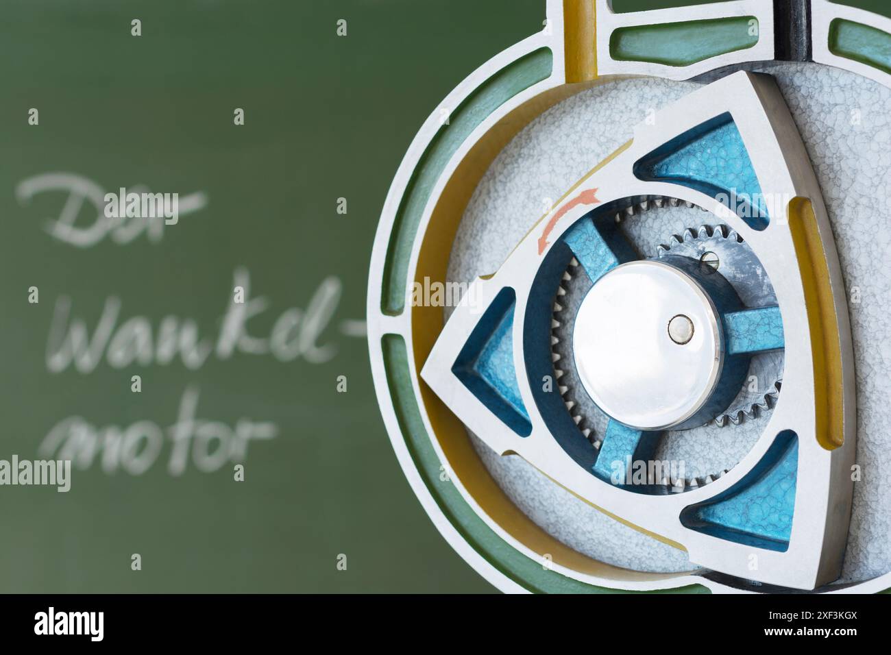 Modello in sezione di un motore rotativo con una tavola sullo sfondo. Testo tedesco sulla lavagna: "Der Wankelmotor" ("il motore Wankel"). Foto Stock