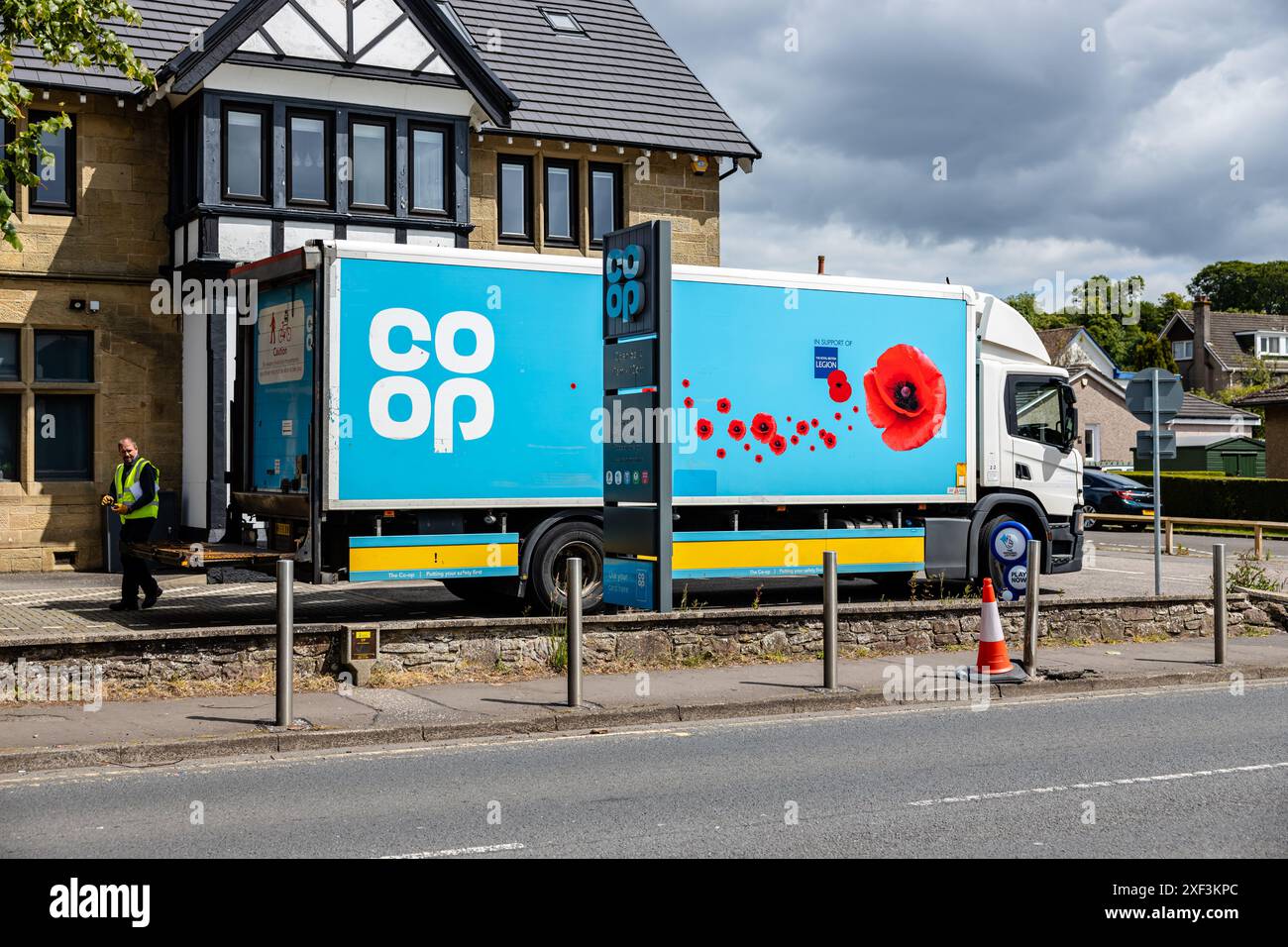 Camion blu co-op con porta posteriore e autista in vista parcheggiato fuori dal negozio locale del villaggio co-op, una casa pubblica convertita. Al Village Store Foto Stock