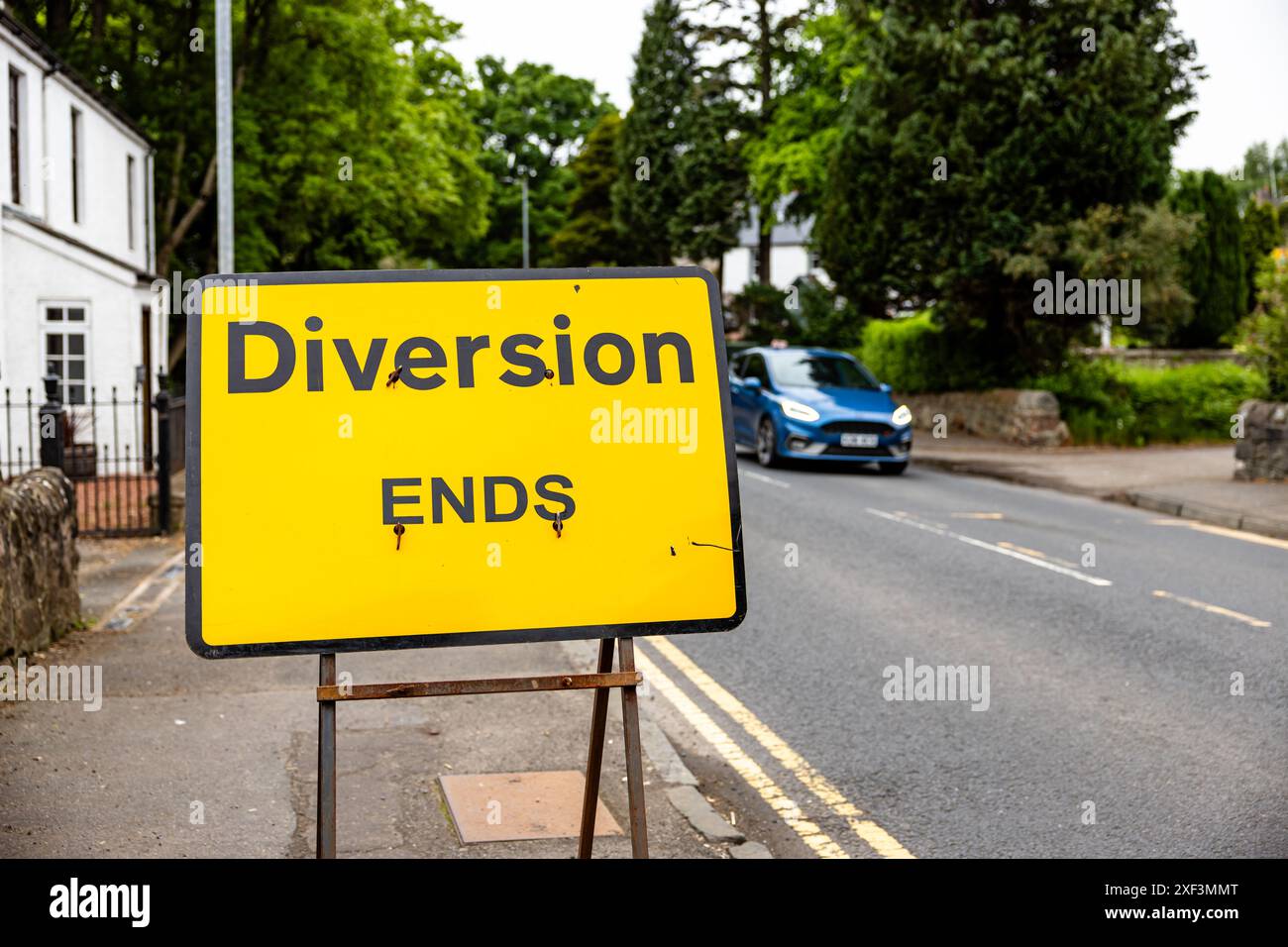 Segno di fine deviazione temporanea nel Regno Unito, un segno giallo con testo nero, che indica che la DEVIAZIONE TERMINA. Si trova su una strada vicino a una strada. Foto Stock