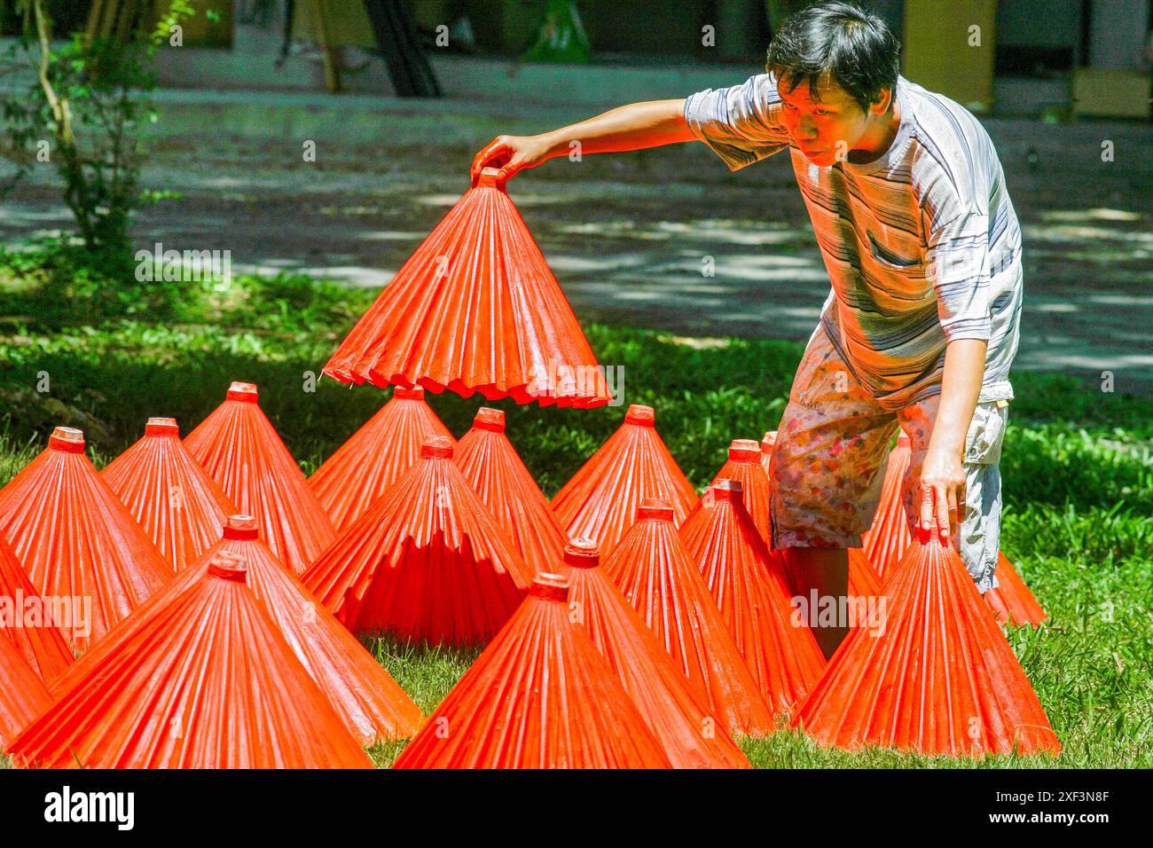 Thailandia, Chiang mai; piccola fabbrica per la produzione di tende da sole di carta. Gli ombrelloni vengono posizionati all'esterno per asciugare la vernice. Foto Stock