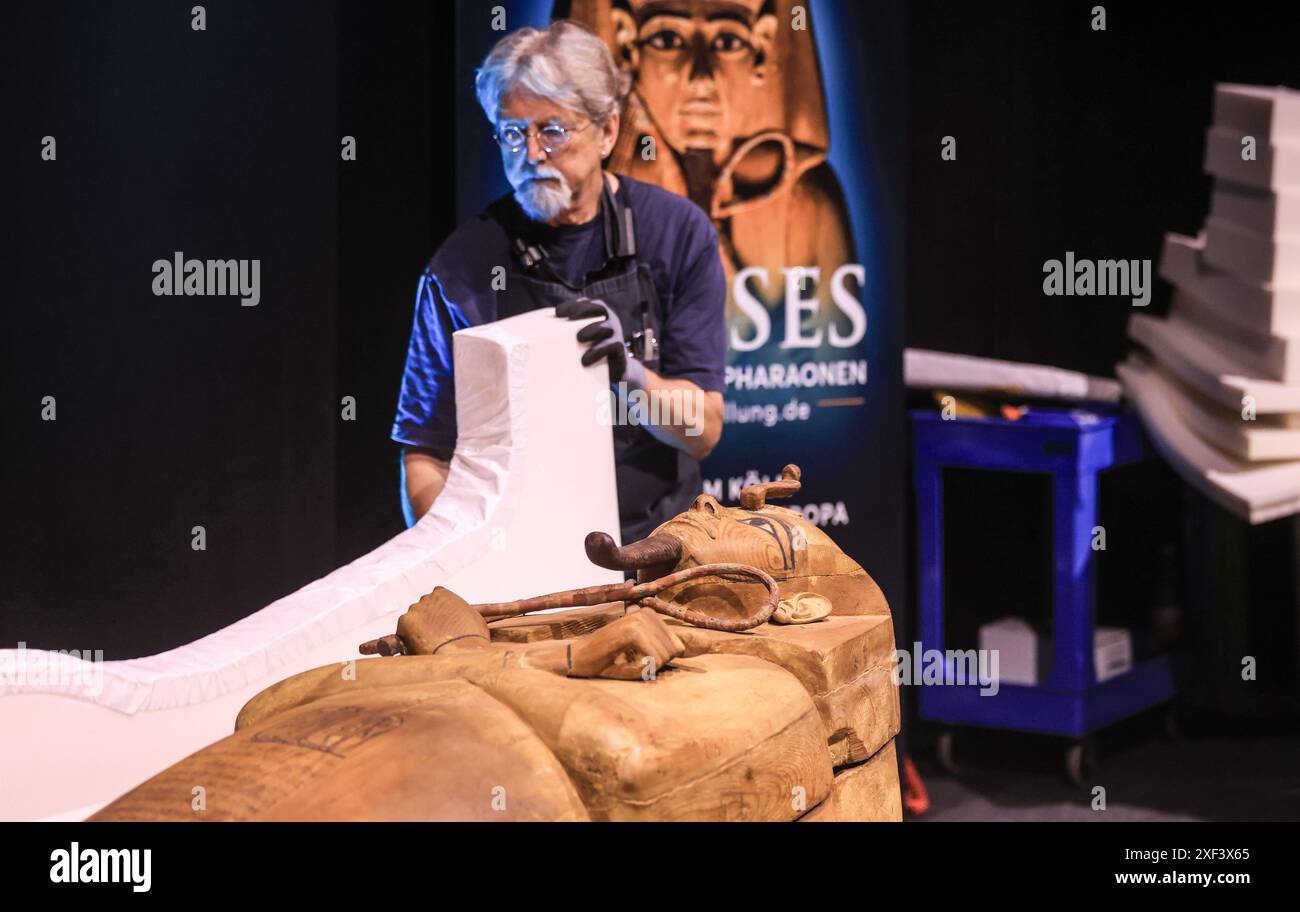 Colonia, Germania. 1 luglio 2024. Il personale del museo svela la bara di Ramses II per la mostra "Ramses & the Gold of the Pharaohs". Questa è la prima volta che la mostra è stata esposta in Germania. Il fulcro e più grande osservatore è il sarcofago di Ramses II, scoperto nel 1811 in una tomba archeologica sulla riva occidentale del Nilo. Crediti: Oliver Berg/dpa/Alamy Live News Foto Stock