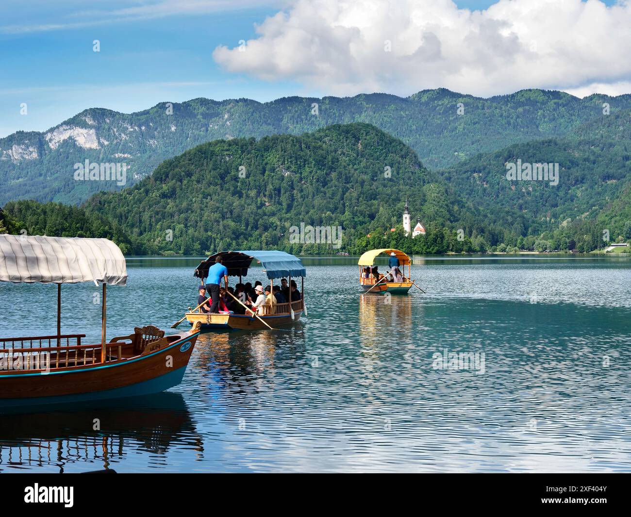 Barche tradizionali in legno o pletna in partenza per l'isola di Bled da Bled, alta Carniola, Slovenia Foto Stock