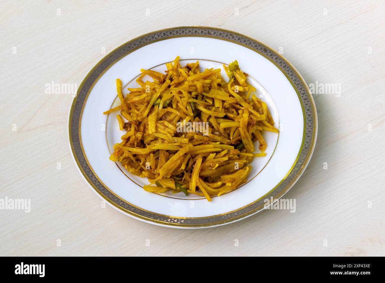 Gustosi bhaji di aloo o o patate grattugiate fritte in un piatto bianco su sfondo di legno. Autentico cibo bengalese, con sottili fette di patate fritte in profondità Foto Stock