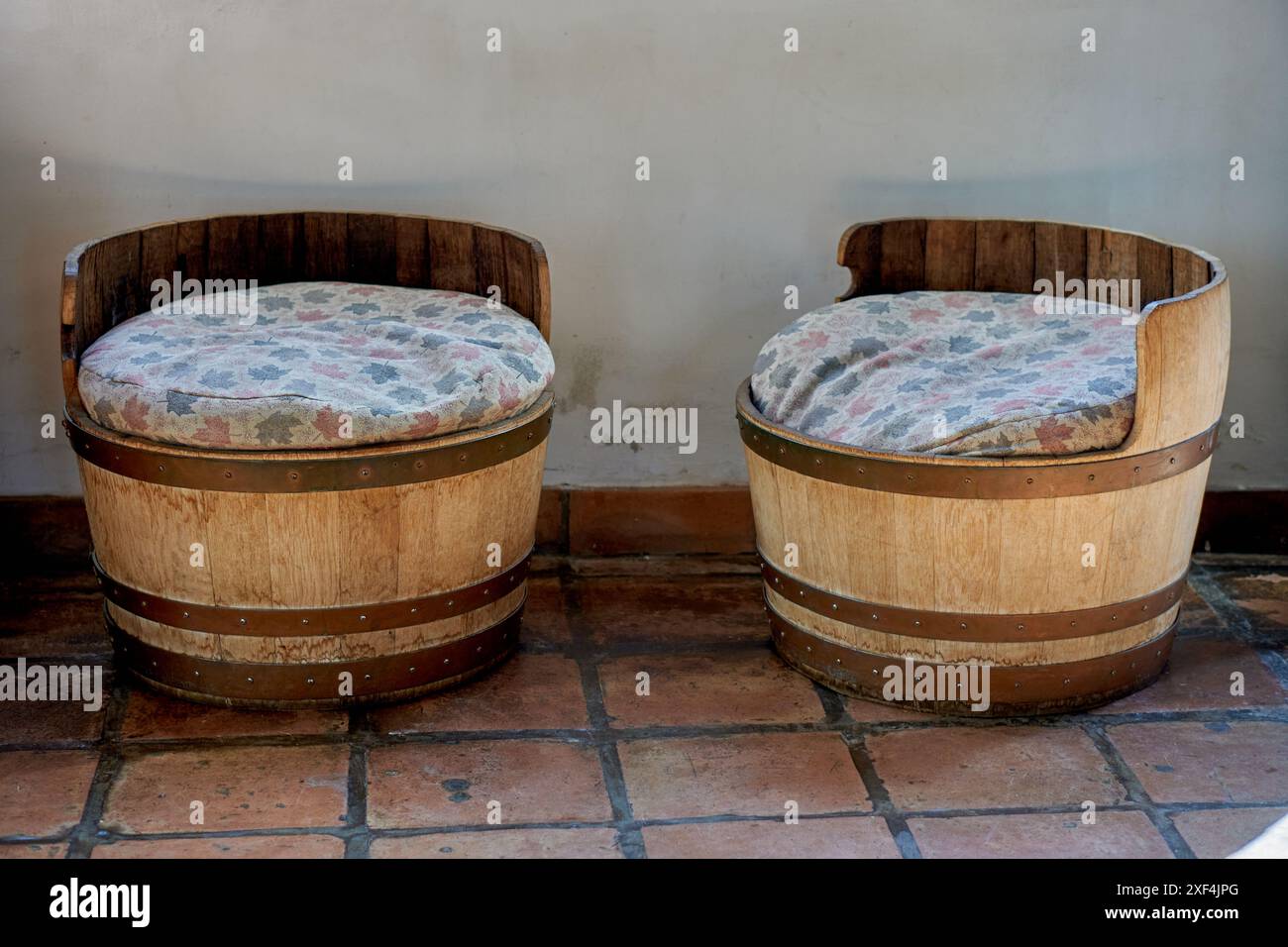 2 vecchi sgabelli rotondi in legno con cuscini sporchi all'interno di un magazzino Foto Stock